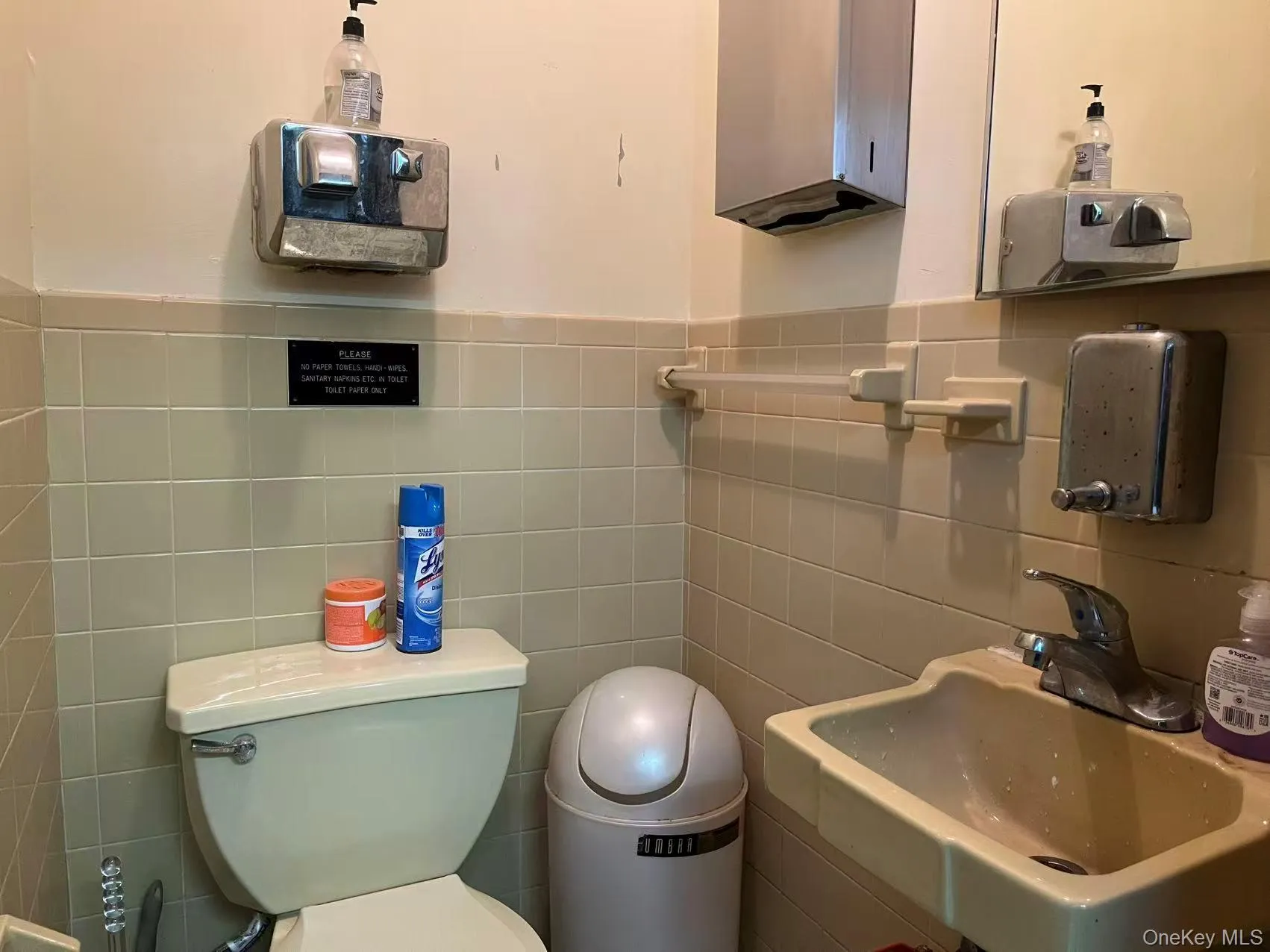 Bathroom featuring toilet and tile walls Bathroom featuring toilet and tile walls