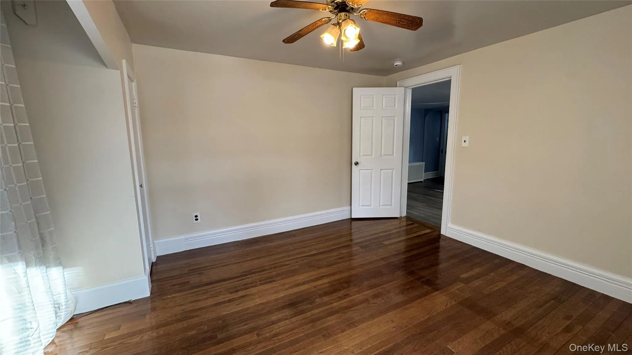 Unfurnished room with dark wood-type flooring and ceiling fan Unfurnished room with dark wood-type flooring and ceiling fan
