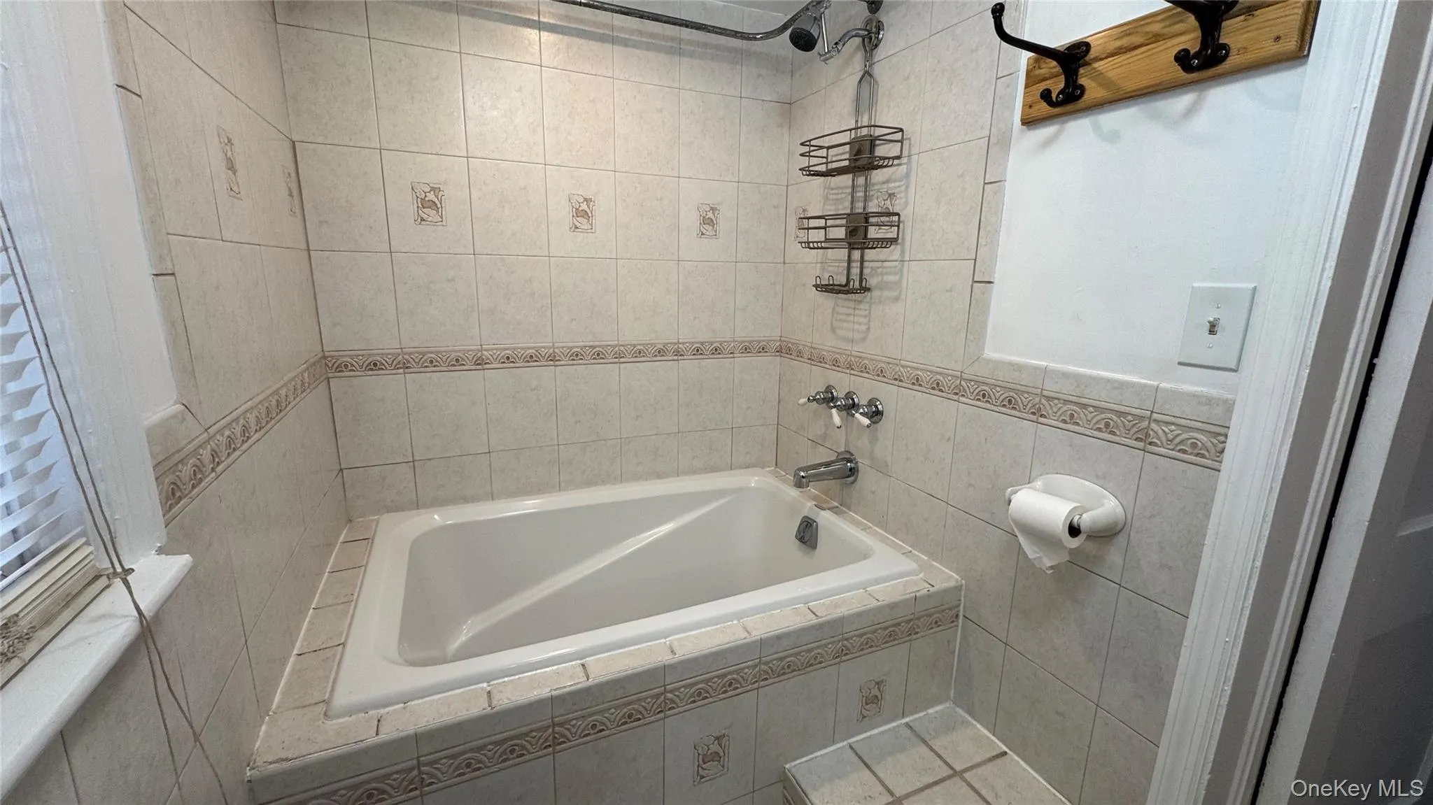 Full bathroom featuring tile walls and tiled shower / bath combo Full bathroom featuring tile walls and tiled shower / bath combo