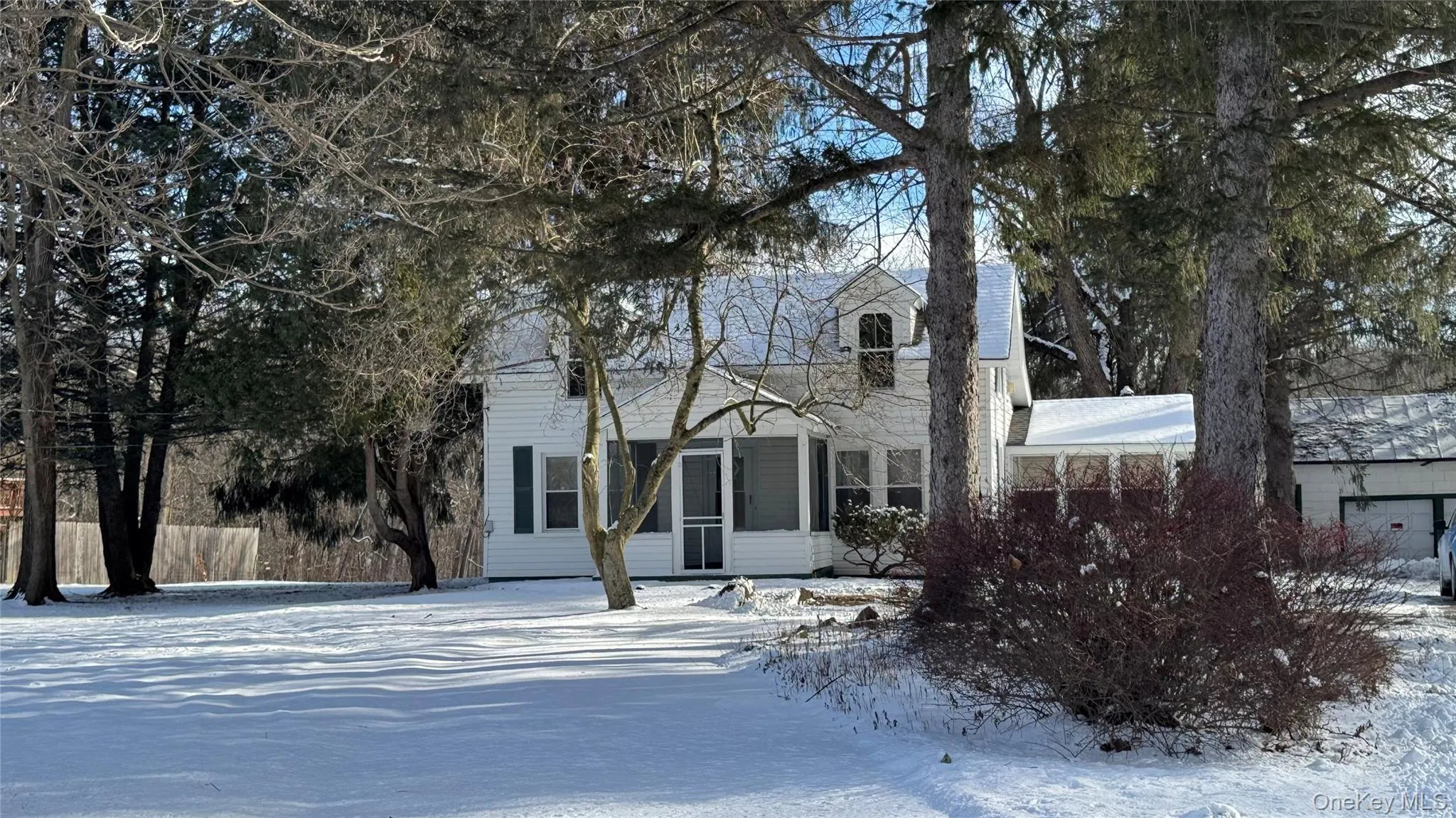 View of front of property featuring a chimney and a sunroom View of front of property featuring a chimney and a sunroom