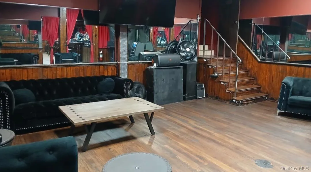 Living area with stairway, wood finished floors, and wood walls Living area with stairway, wood finished floors, and wood walls