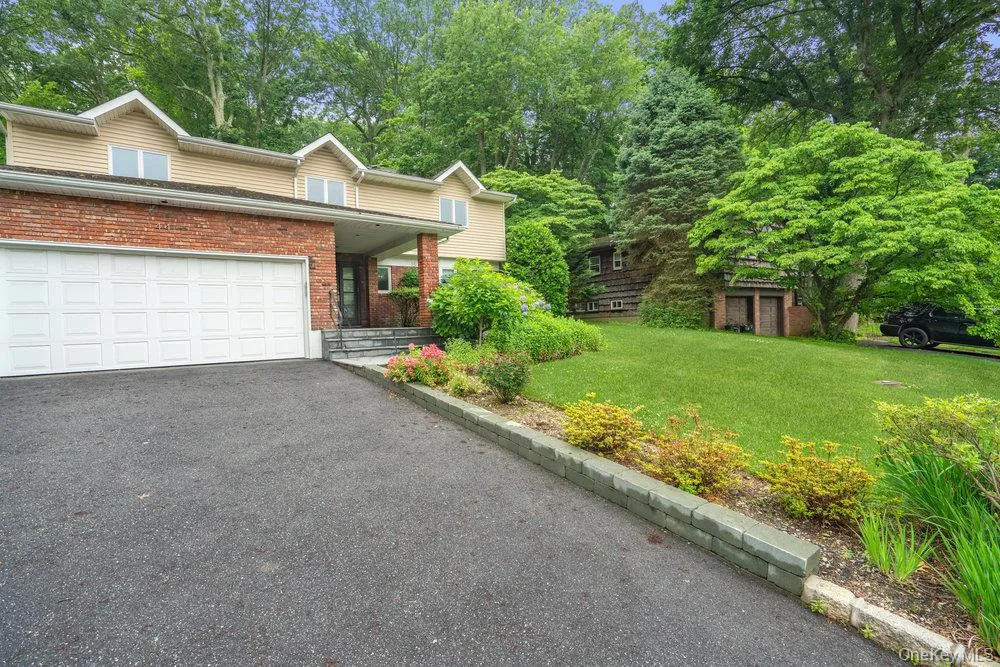 View of front facade with a front yard, brick siding, covered porch, driveway, and a garage View of front facade with a front yard, brick siding, covered porch, driveway, and a garage
