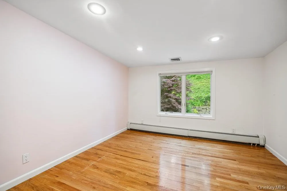 Empty room featuring baseboard heating, light wood-type flooring, and recessed lighting Empty room featuring baseboard heating, light wood-type flooring, and recessed lighting