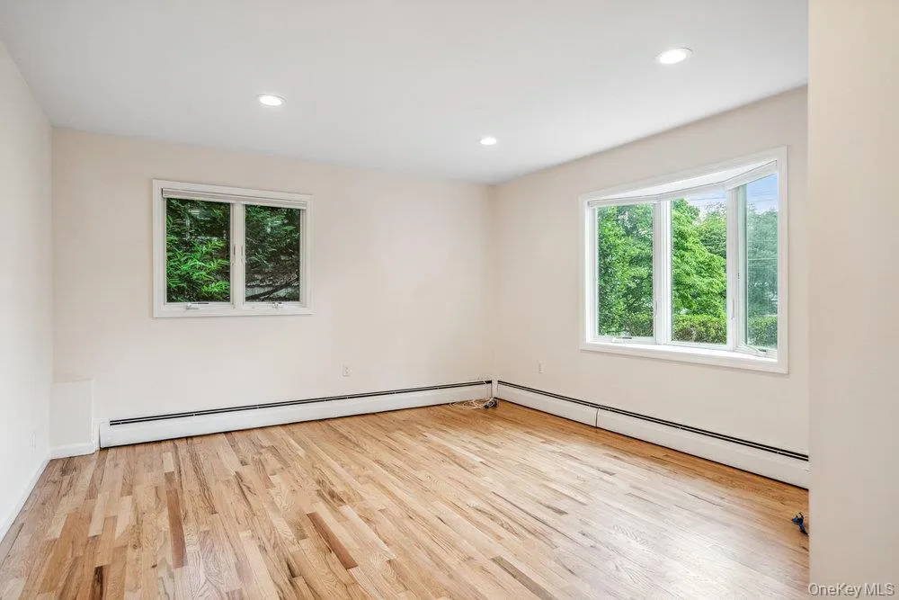 Spare room featuring light wood-style floors, a baseboard radiator, plenty of natural light, and recessed lighting Spare room featuring light wood-style floors, a baseboard radiator, plenty of natural light, and recessed lighting