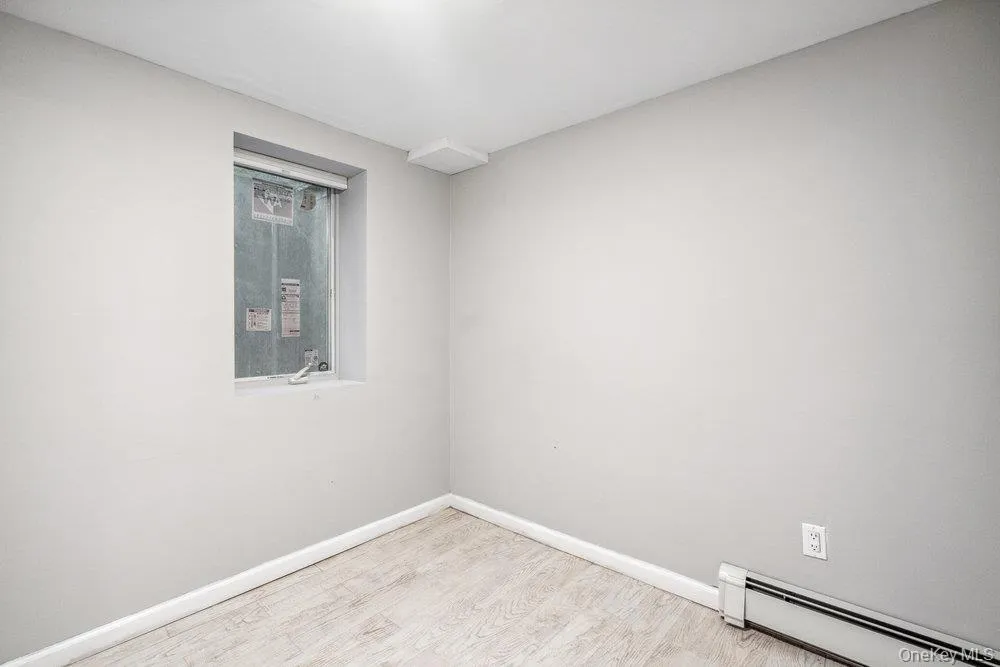 Spare room featuring baseboard heating and wood finished floors Spare room featuring baseboard heating and wood finished floors