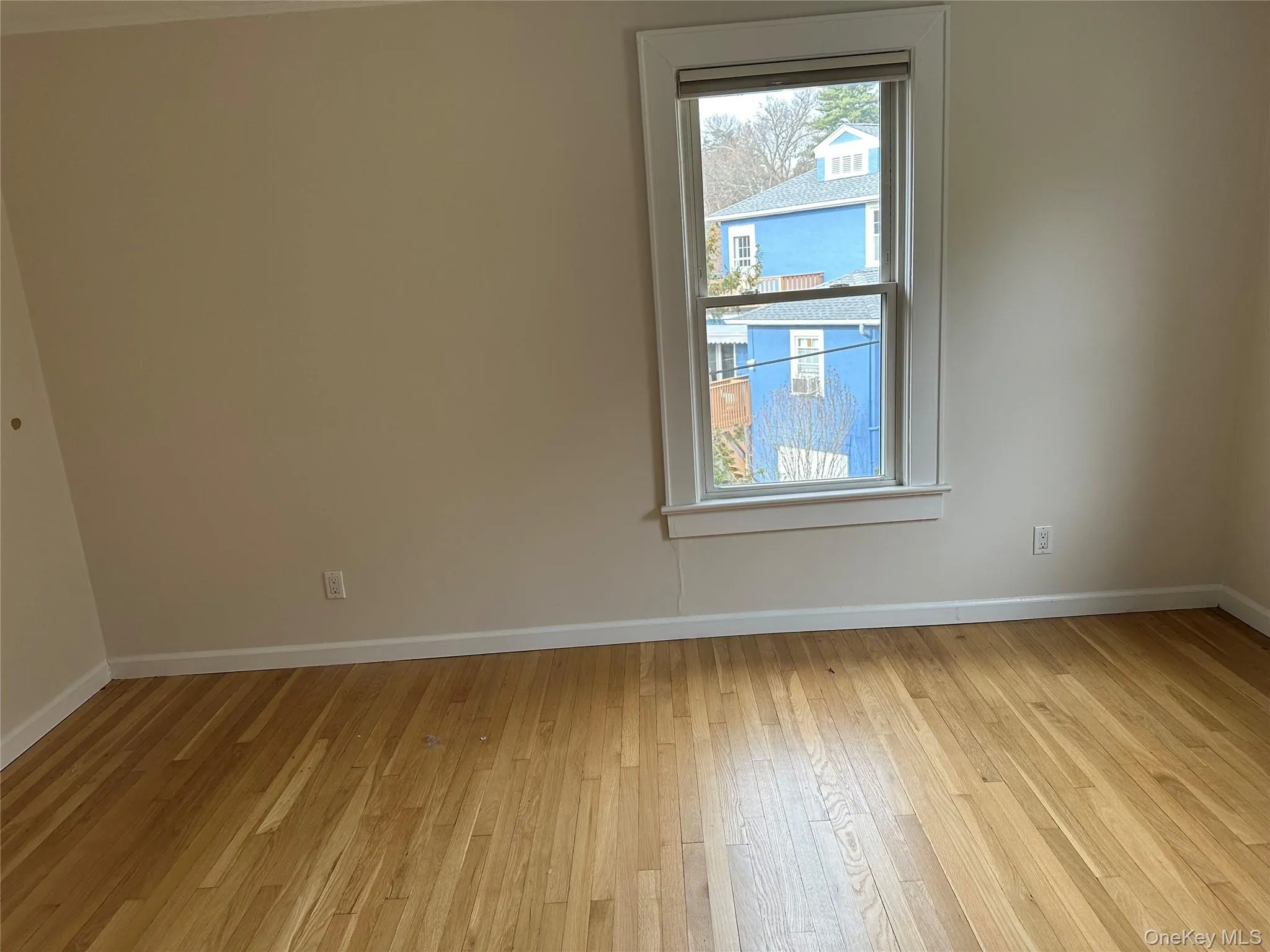 Empty room with baseboards and light wood-style flooring Empty room with baseboards and light wood-style flooring