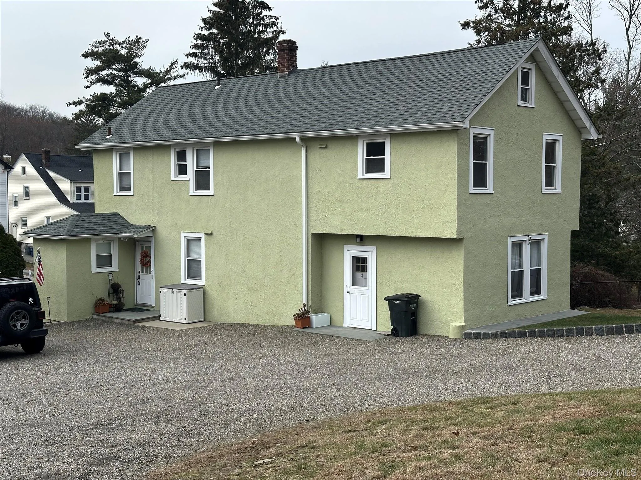 Back of house with stucco siding, a chimney, and a shingled roof Back of house with stucco siding, a chimney, and a shingled roof
