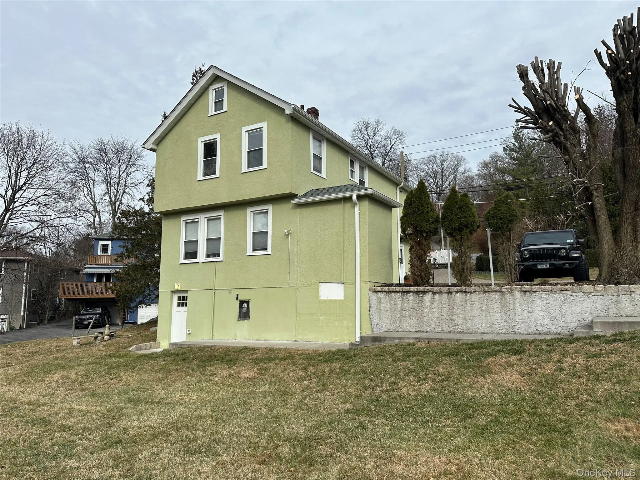 Rear view of house featuring a yard and stucco siding Rear view of house featuring a yard and stucco siding