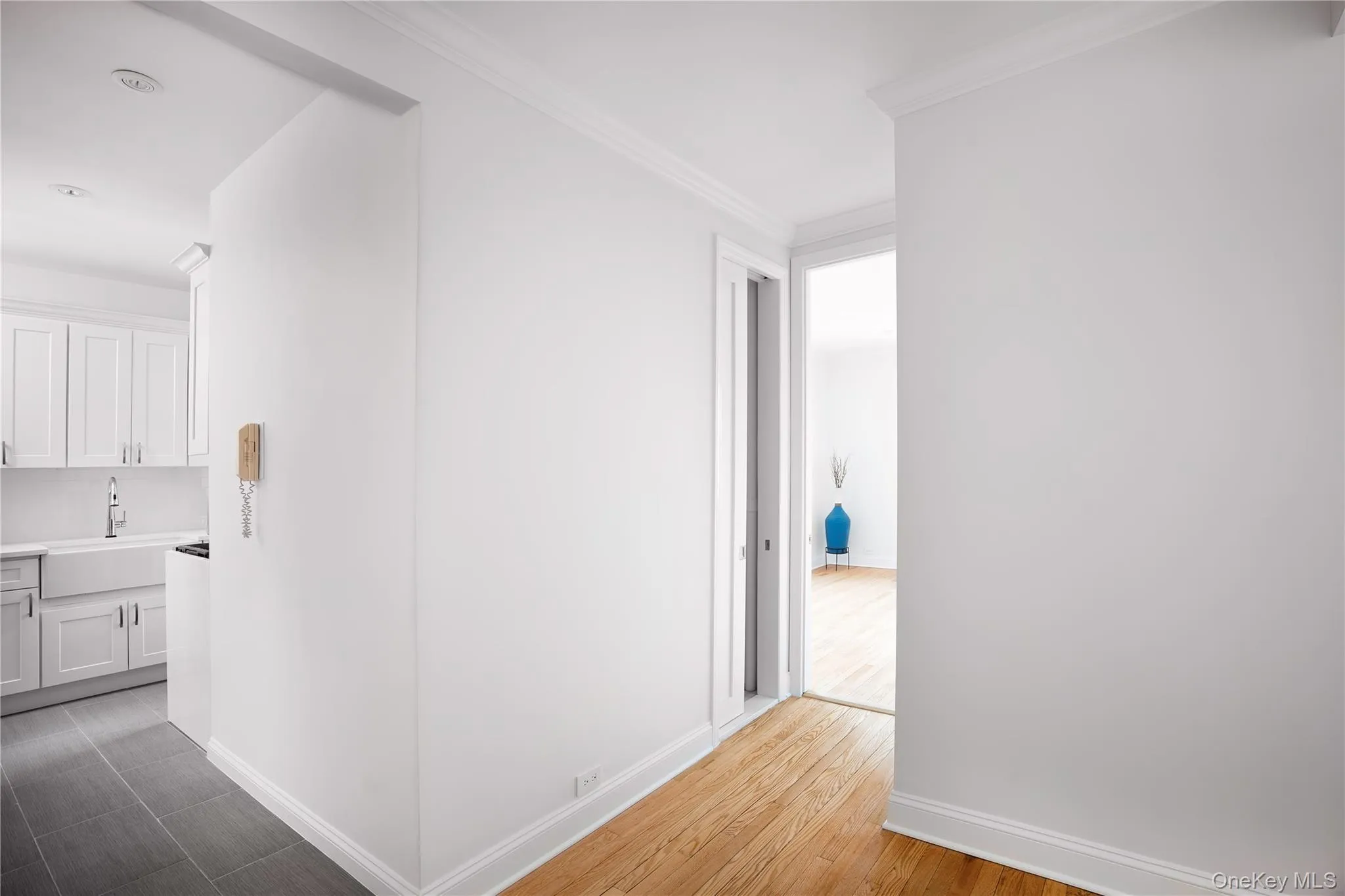 Hall with light wood-style floors and ornamental molding Hall with light wood-style floors and ornamental molding