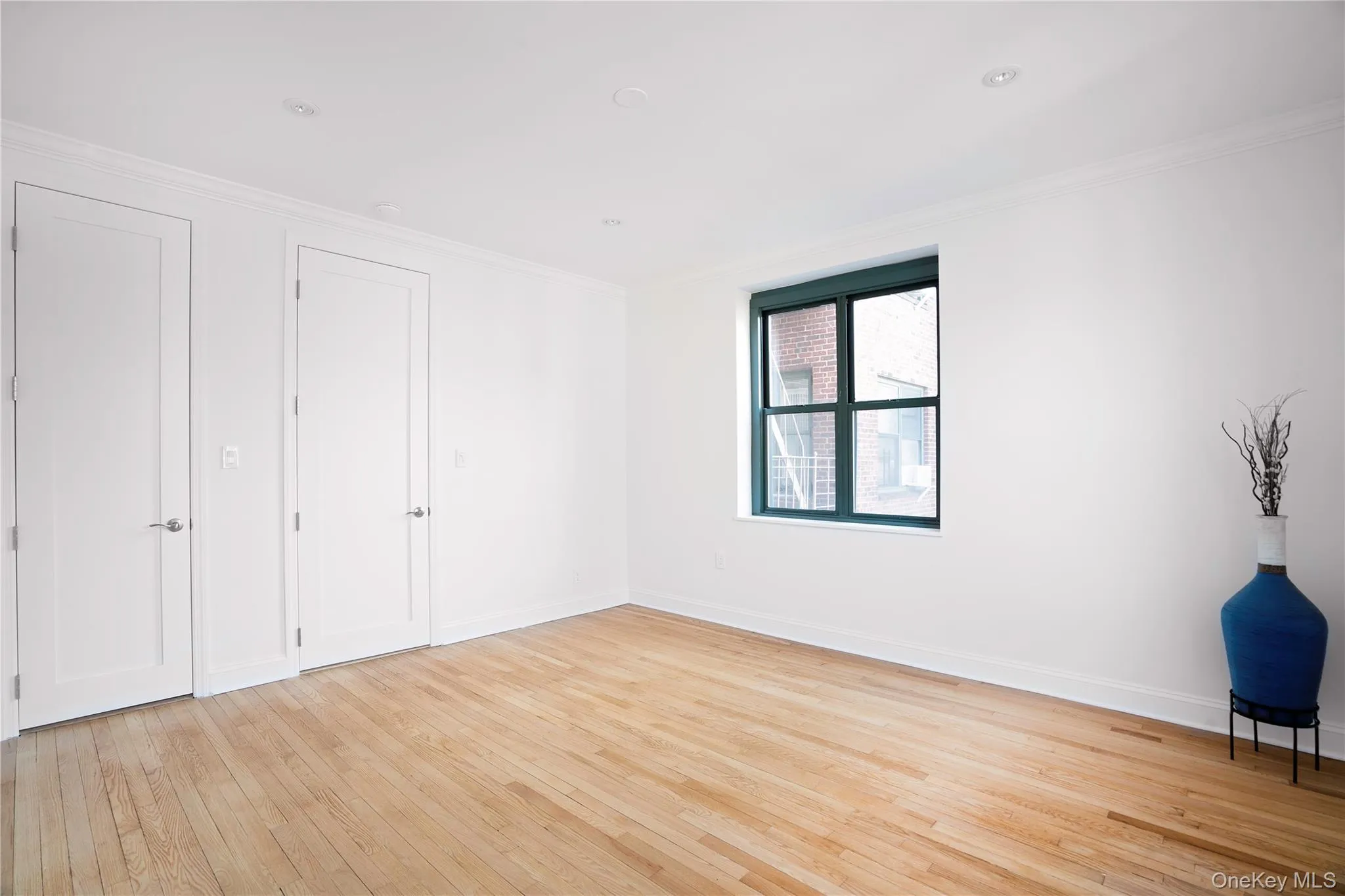 Unfurnished bedroom featuring crown molding and light wood finished floors Unfurnished bedroom featuring crown molding and light wood finished floors