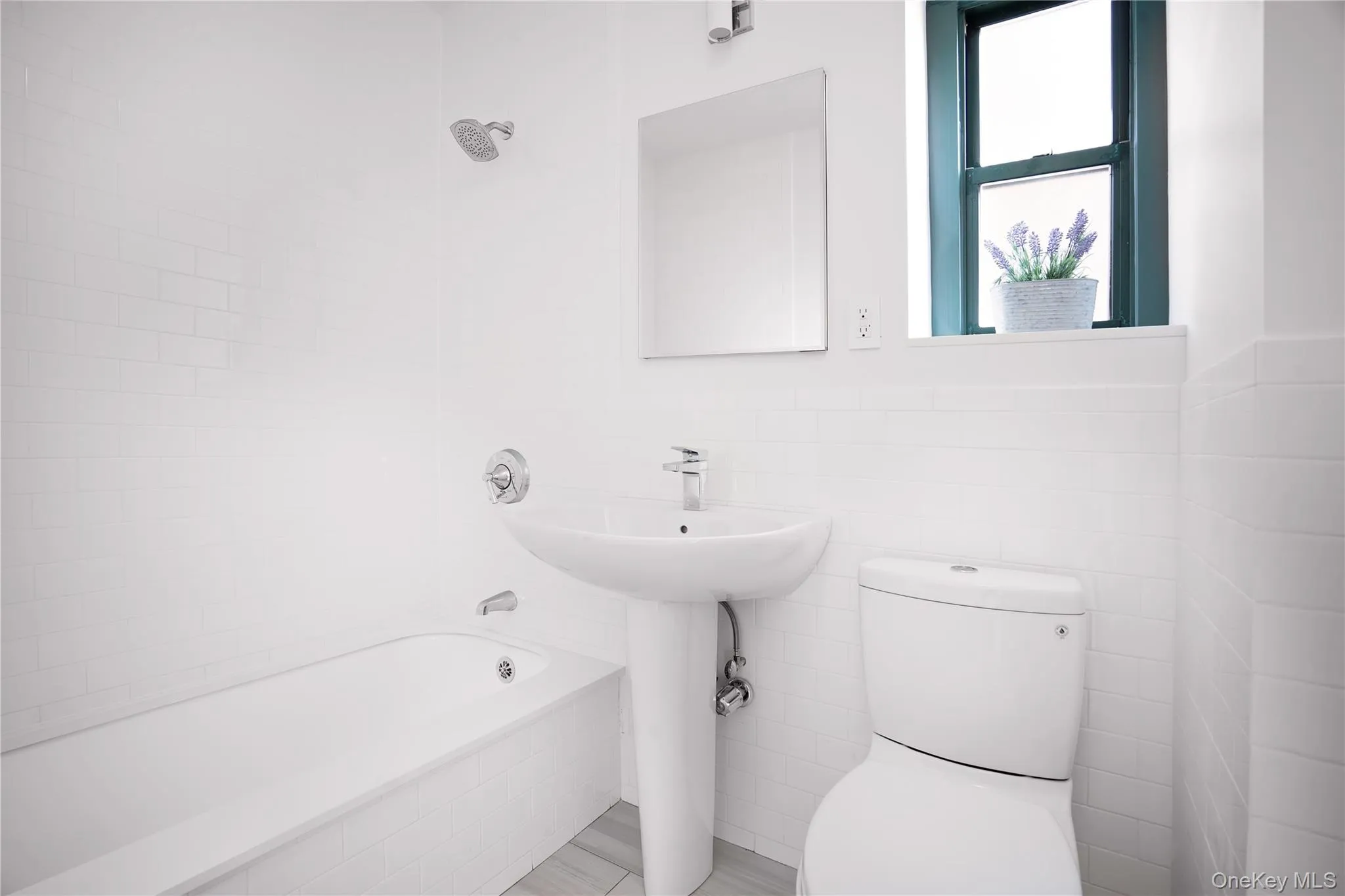 Bathroom featuring tile walls and tiled shower / bath Bathroom featuring tile walls and tiled shower / bath