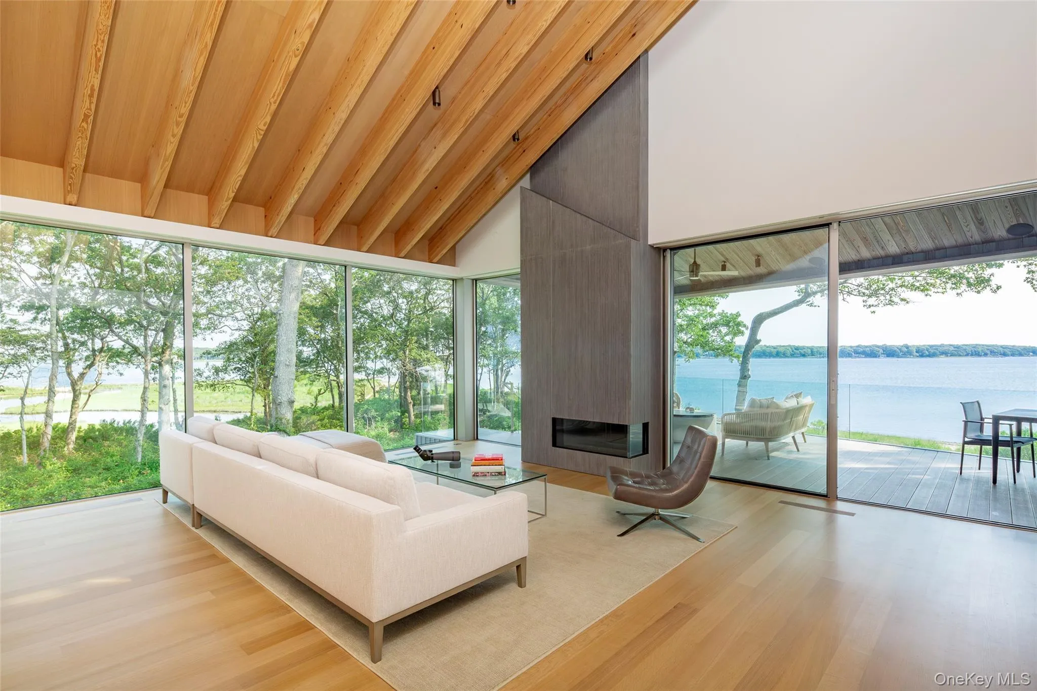 Sunroom featuring a water view, wood finished floors, high vaulted ceiling, healthy amount of natural light, and wood ceiling Sunroom featuring a water view, wood finished floors, high vaulted ceiling, healthy amount of natural light, and wood ceiling