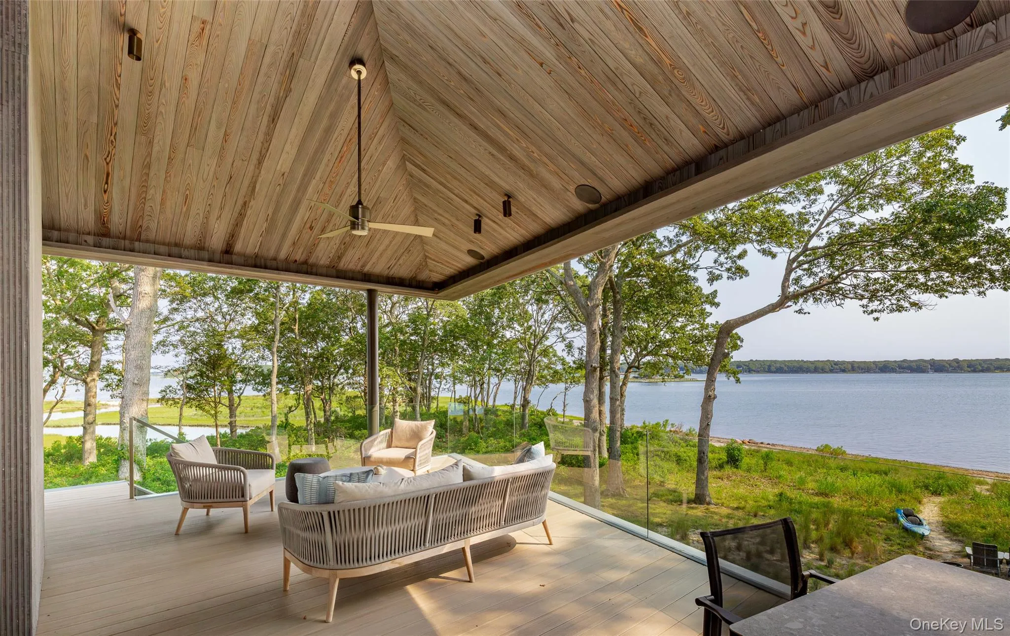 View of patio / terrace featuring an outdoor living space and a deck with water view View of patio / terrace featuring an outdoor living space and a deck with water view