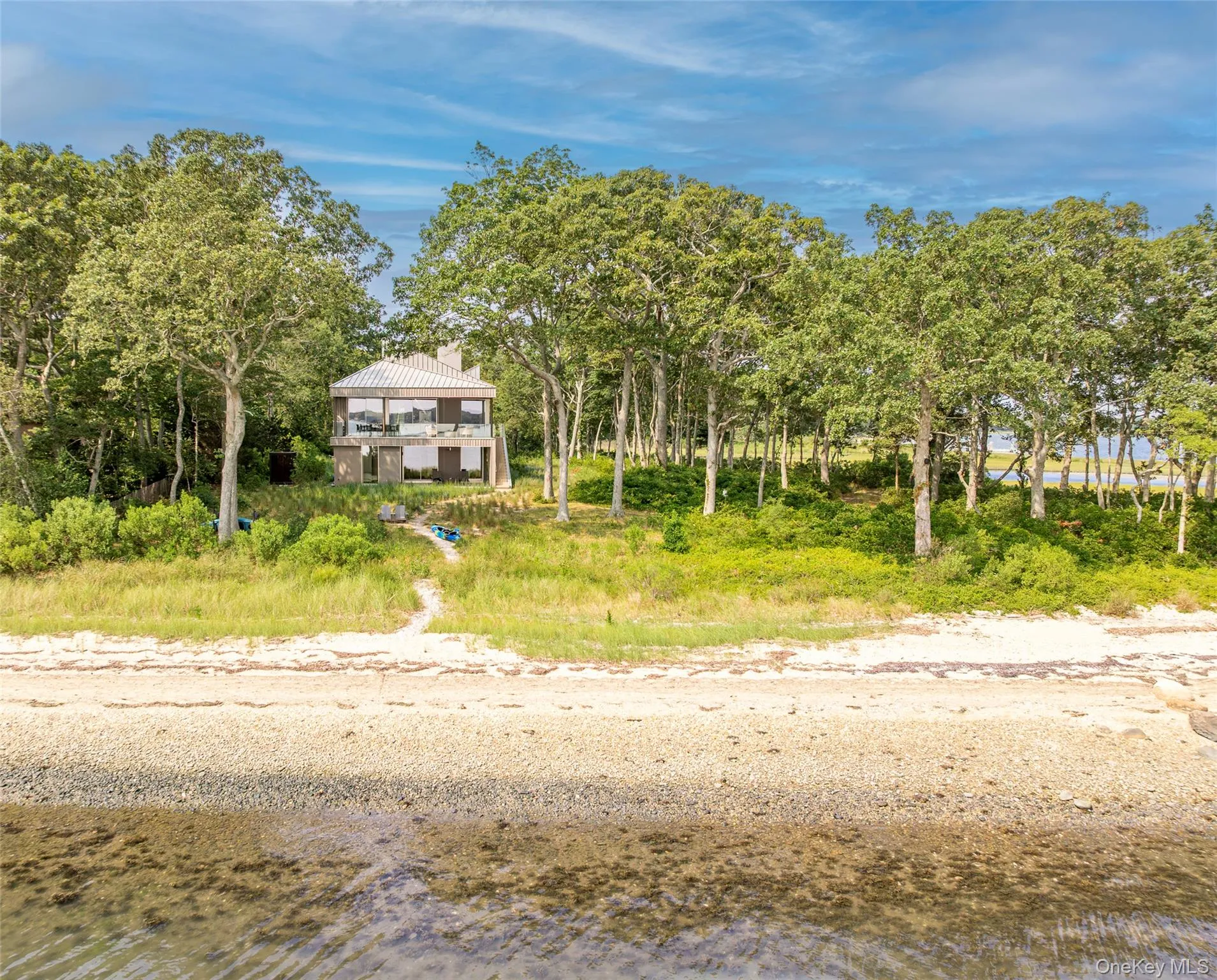 Beach home featuring a water view and a chimney Beach home featuring a water view and a chimney