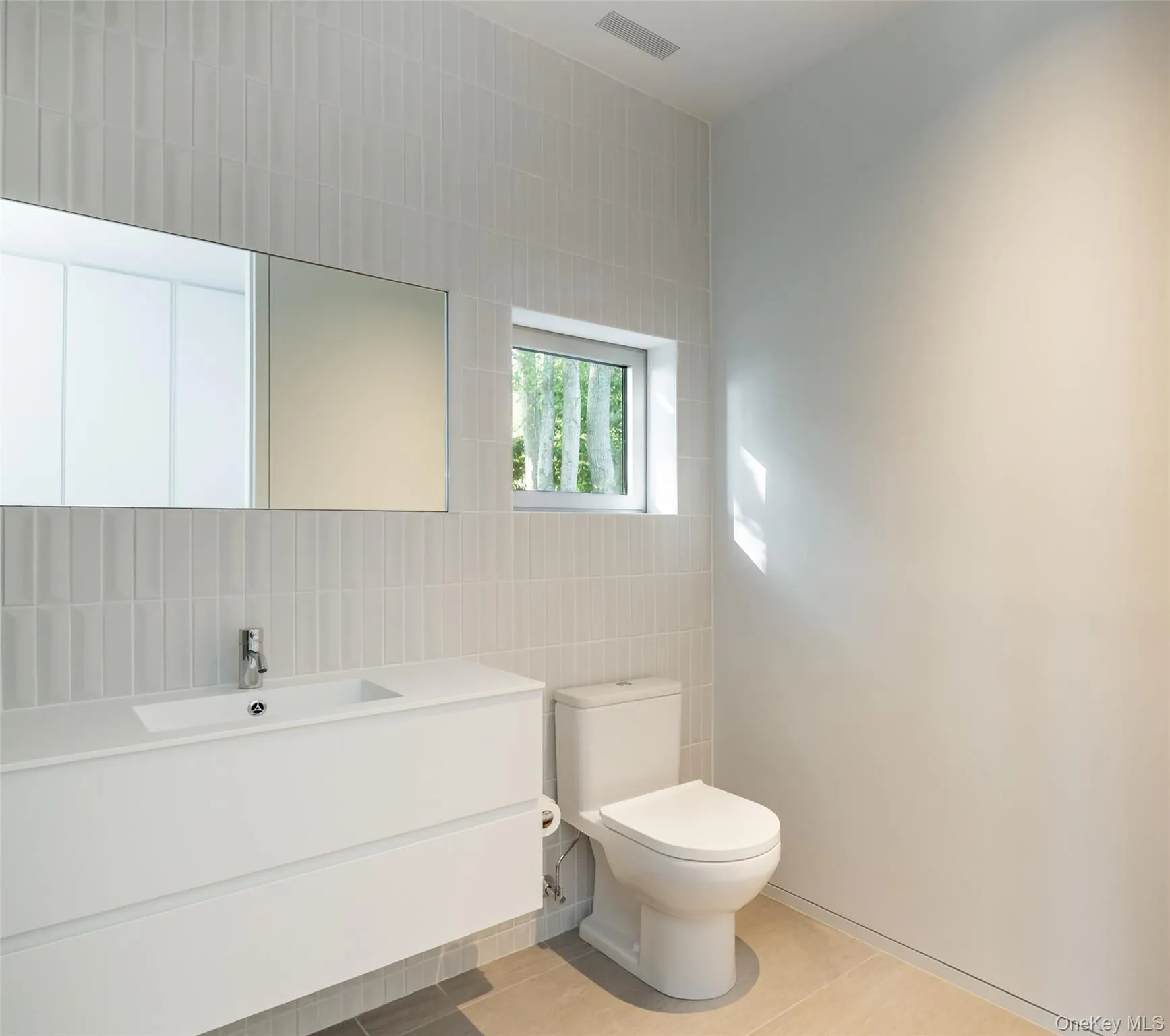 Bathroom featuring tile walls, vanity, and light tile patterned flooring Bathroom featuring tile walls, vanity, and light tile patterned flooring