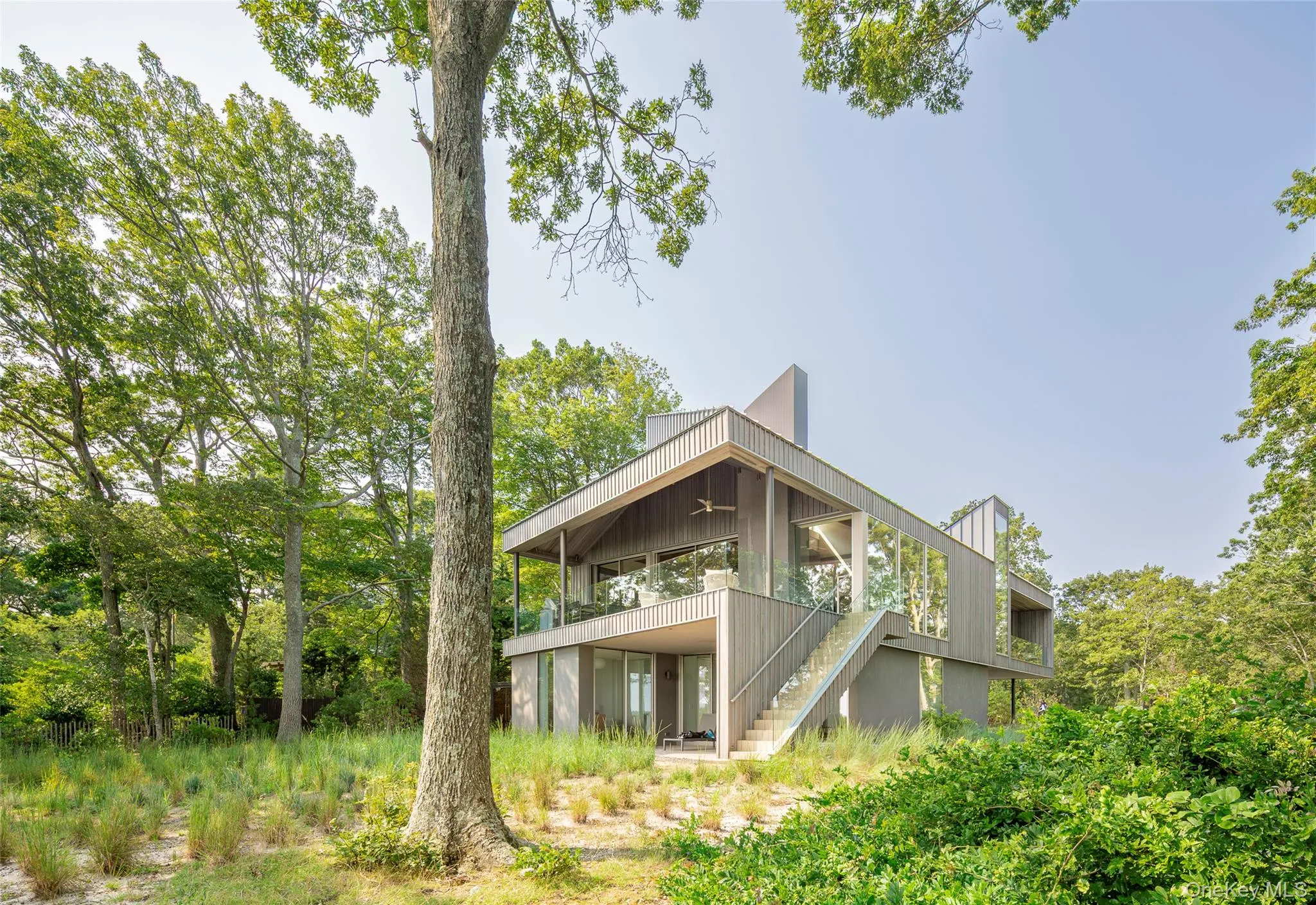 Back of property featuring stairs, ceiling fan, and a balcony Back of property featuring stairs, ceiling fan, and a balcony