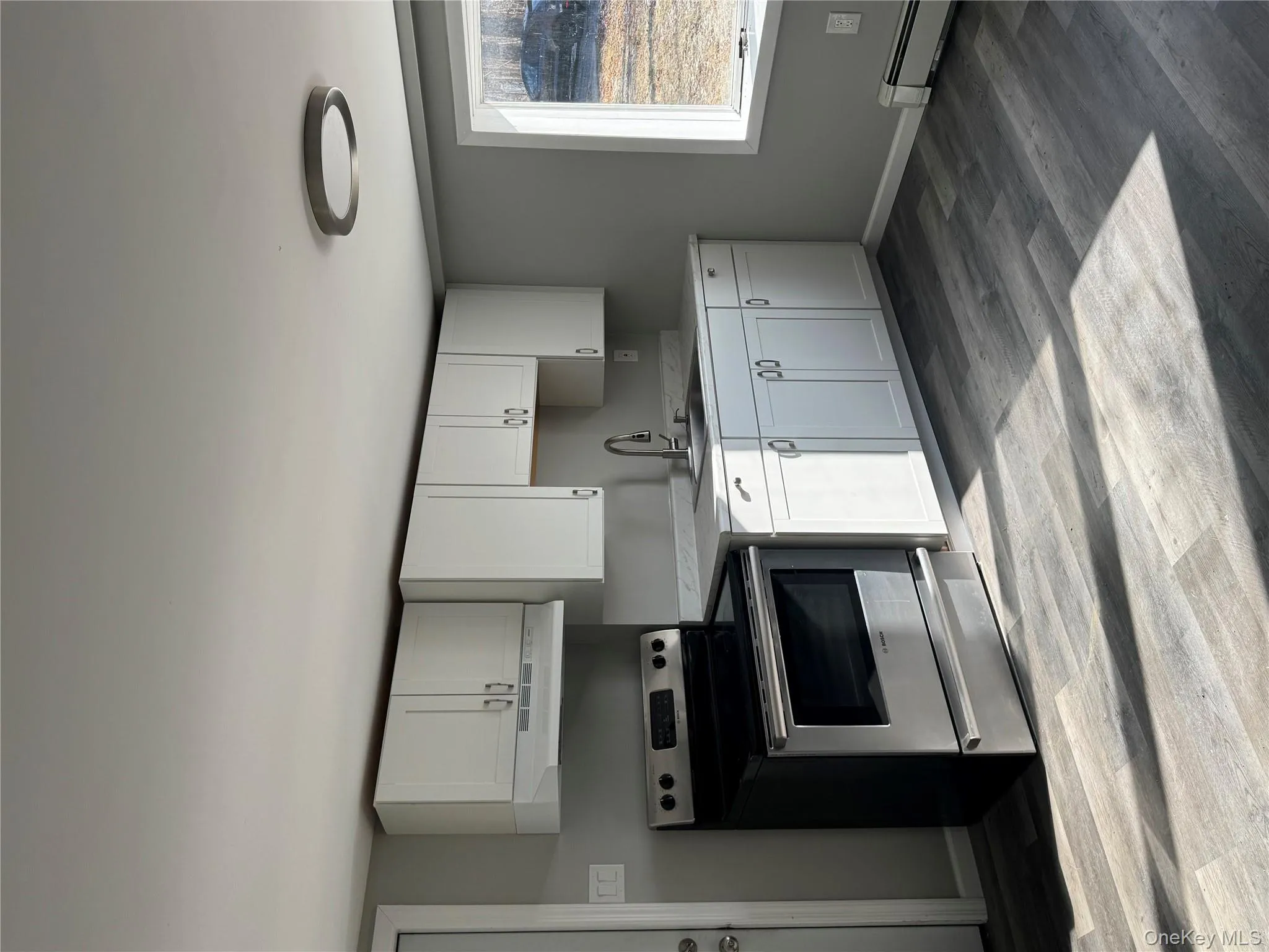 Kitchen featuring stove, white cabinets, sink, light hardwood / wood-style flooring, and range hood Kitchen featuring stove, white cabinets, sink, light hardwood / wood-style flooring, and range hood