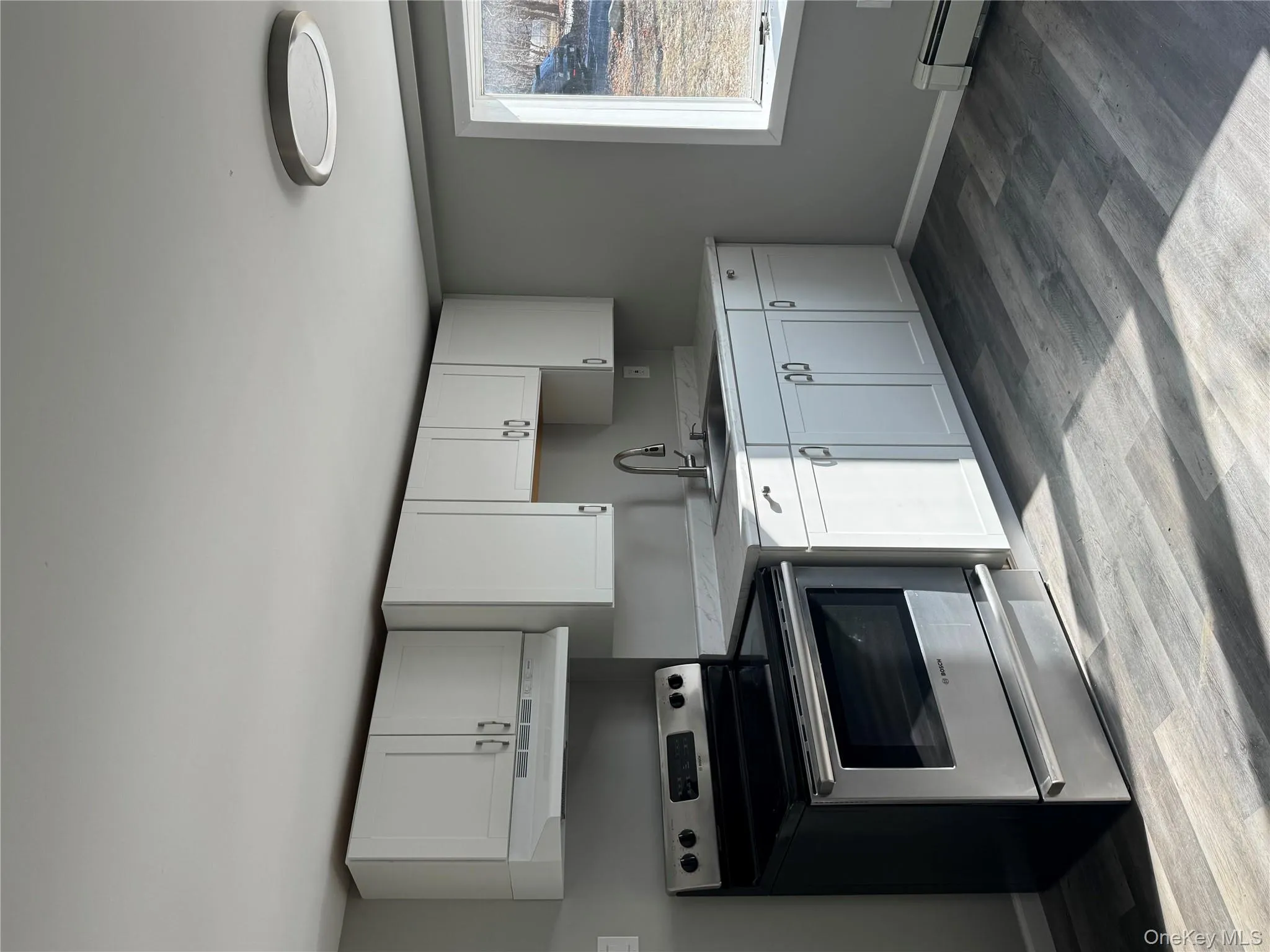 Kitchen featuring white cabinetry, sink, stove, light hardwood / wood-style floors, and extractor fan Kitchen featuring white cabinetry, sink, stove, light hardwood / wood-style floors, and extractor fan