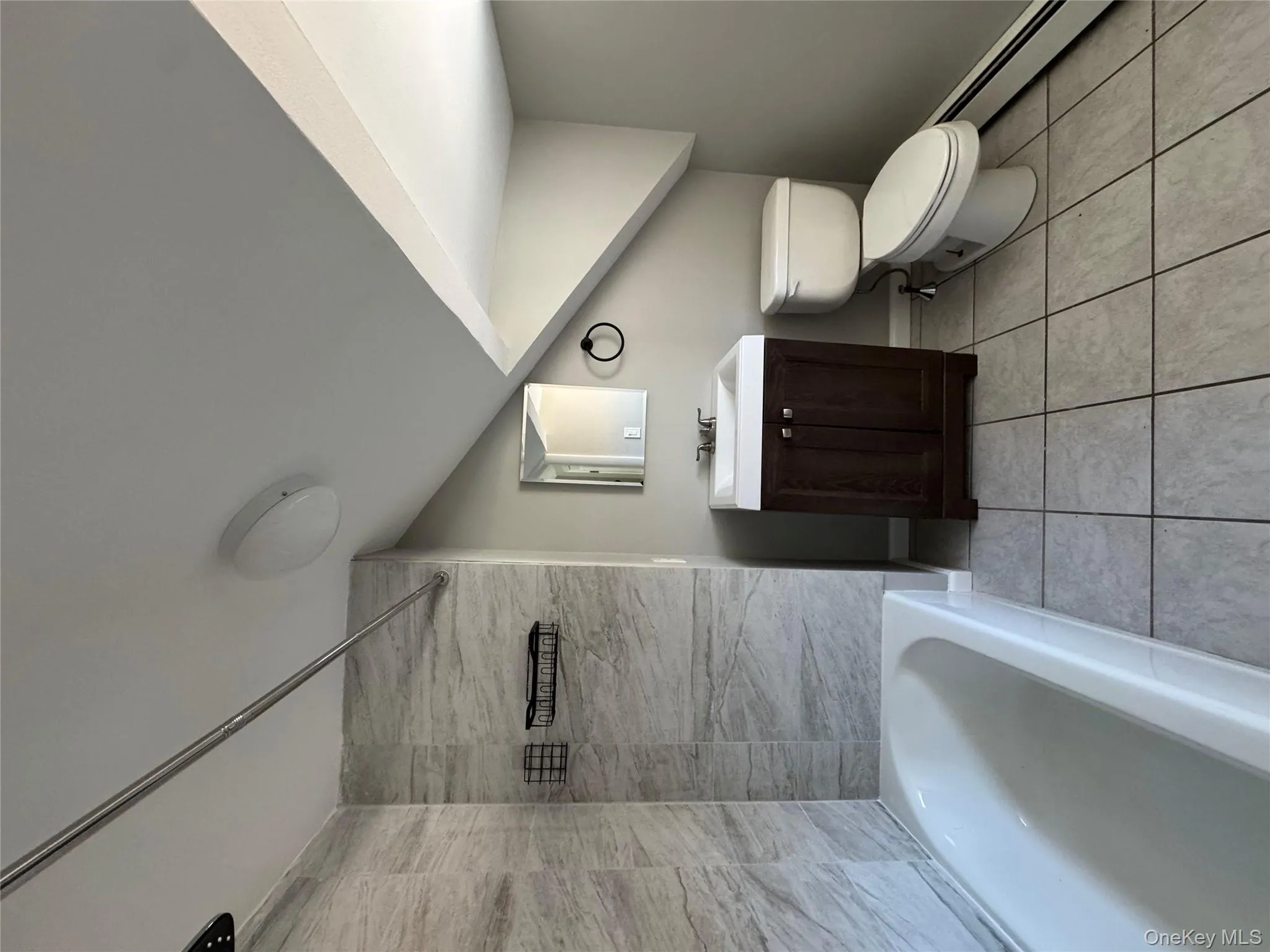 Full bathroom with vanity, shower combination, tile patterned flooring, toilet, and a baseboard radiator Full bathroom with vanity, shower combination, tile patterned flooring, toilet, and a baseboard radiator