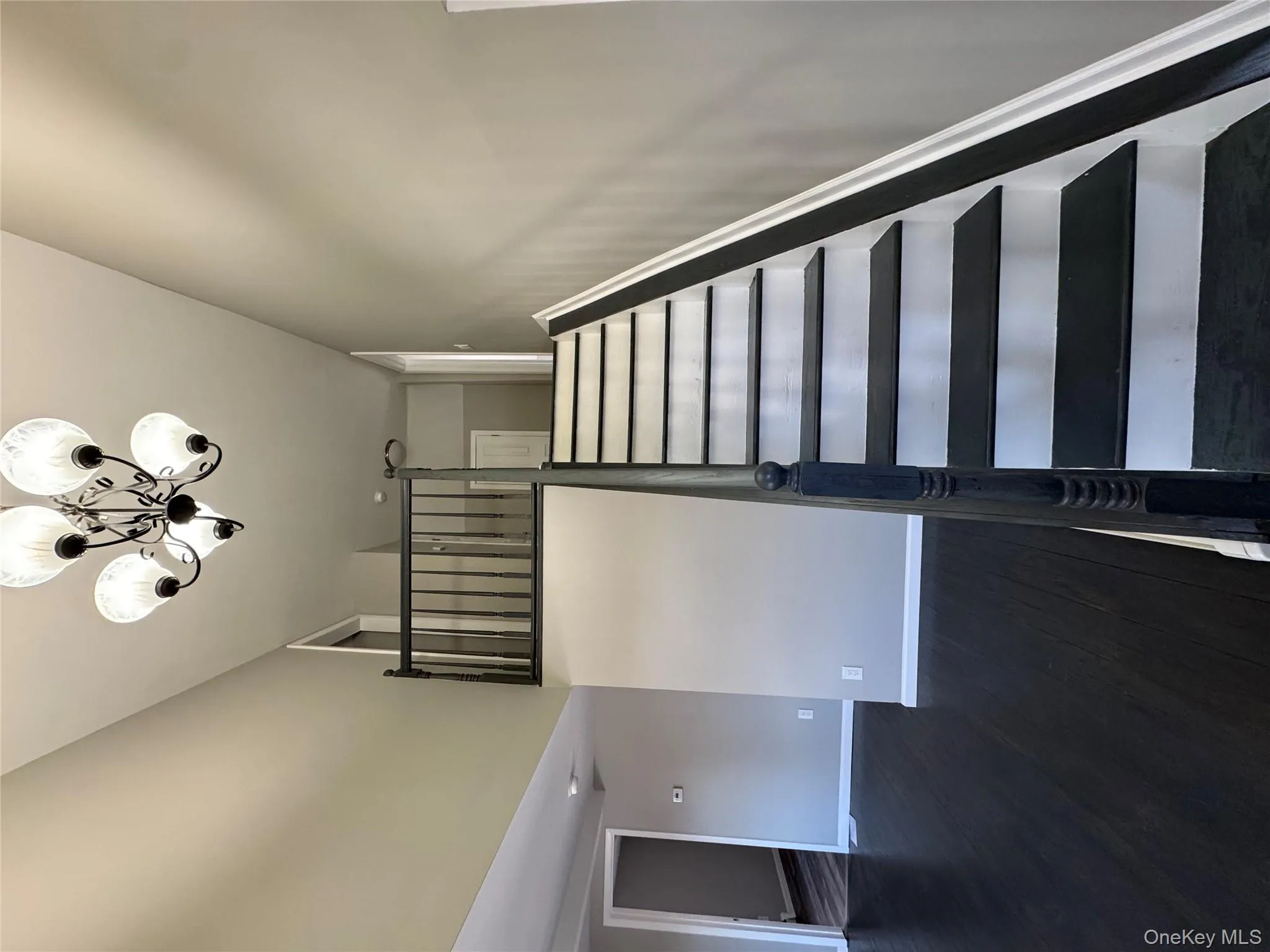 Staircase with a chandelier and hardwood / wood-style floors Staircase with a chandelier and hardwood / wood-style floors