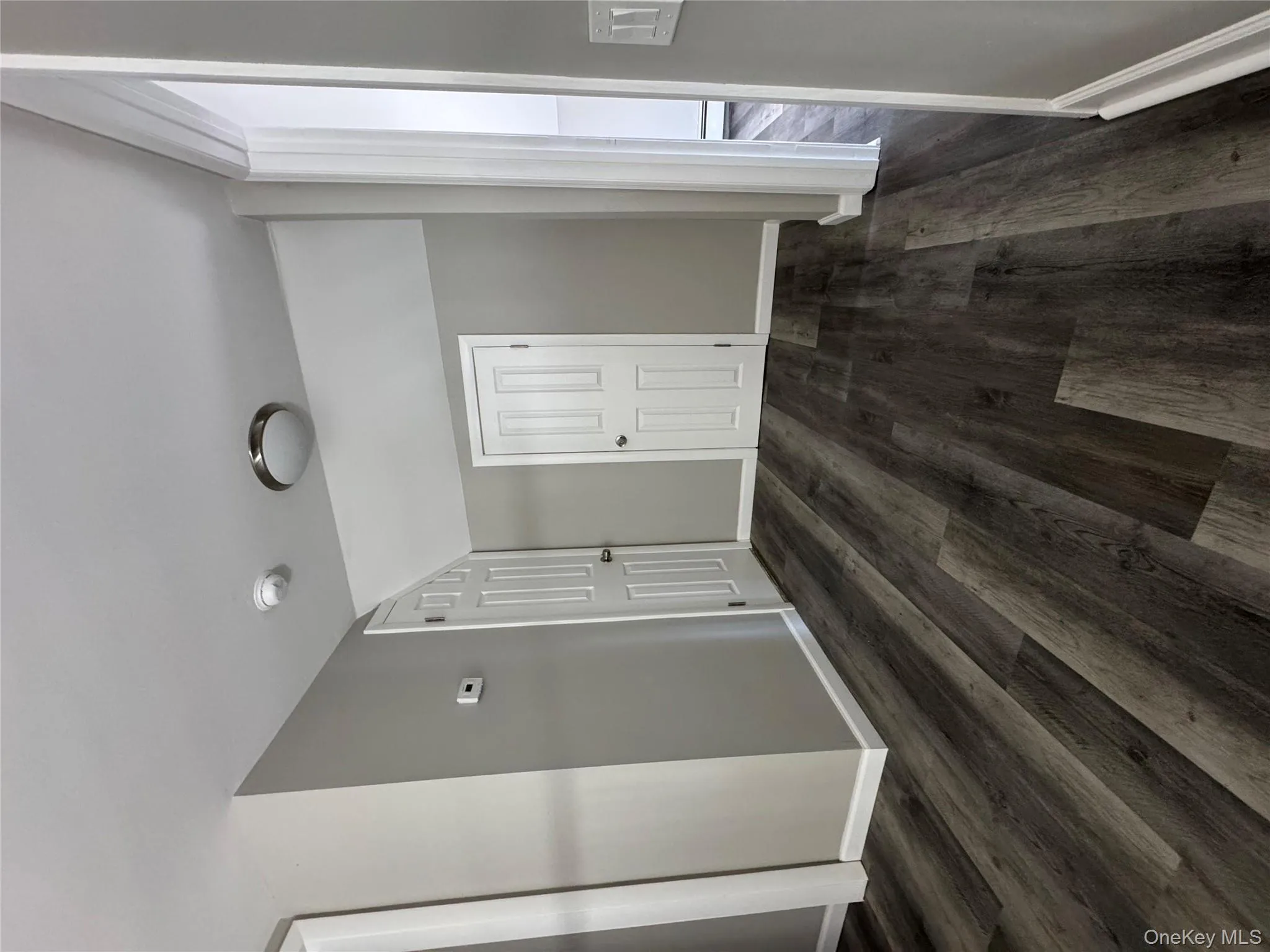Hallway featuring vaulted ceiling, dark wood-type flooring, and a baseboard heating unit Hallway featuring vaulted ceiling, dark wood-type flooring, and a baseboard heating unit