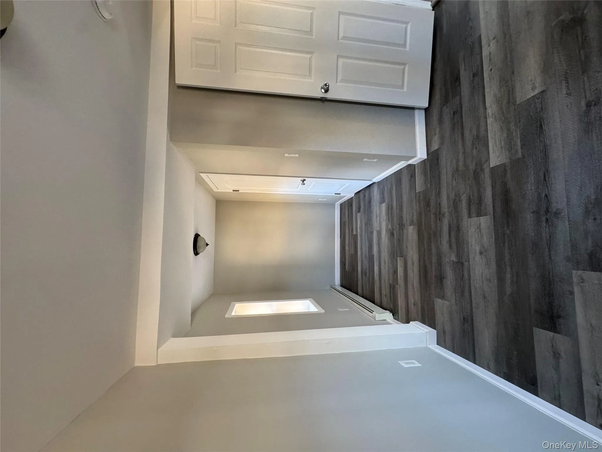 Corridor featuring a baseboard radiator and dark hardwood / wood-style floors Corridor featuring a baseboard radiator and dark hardwood / wood-style floors