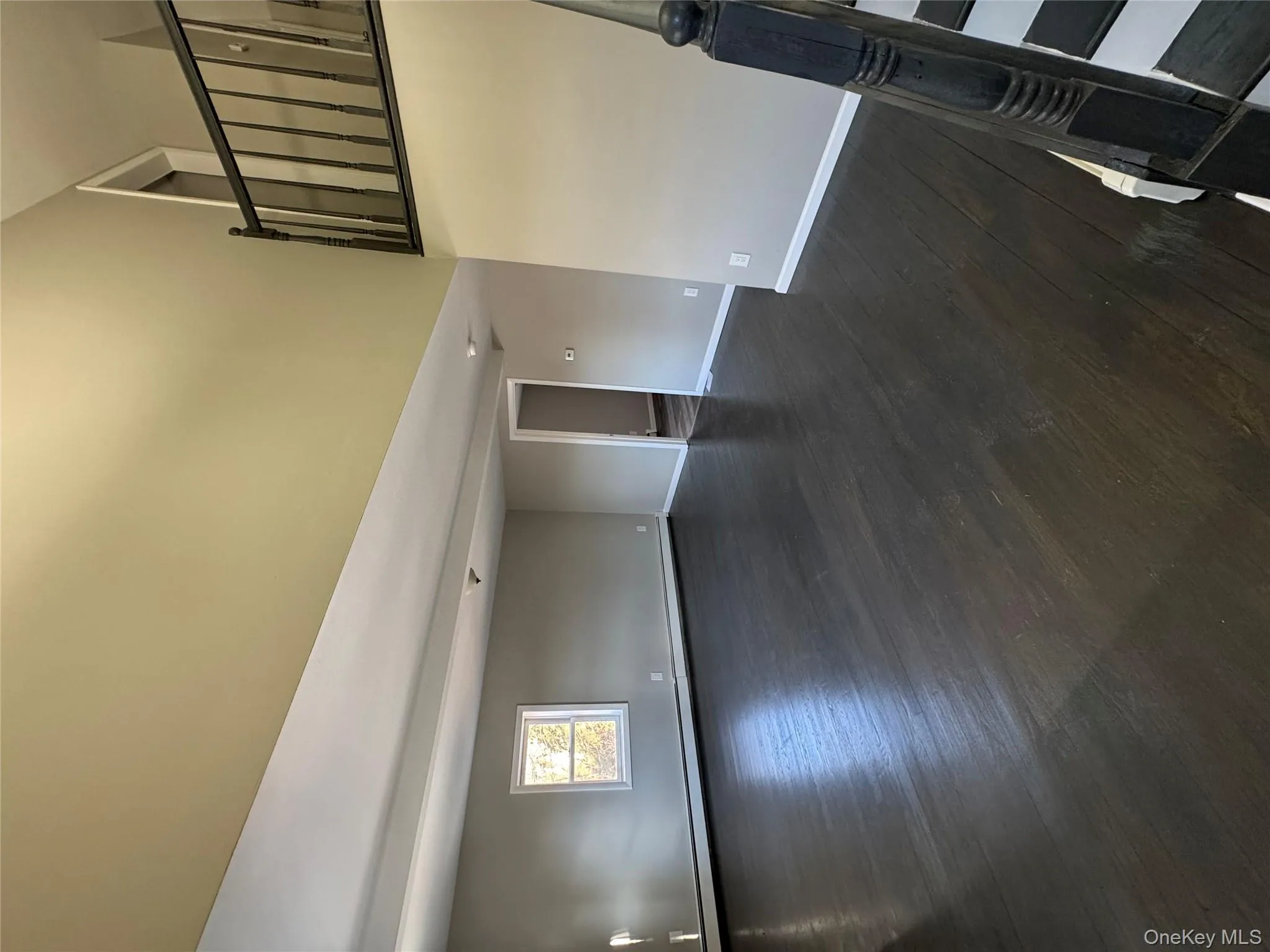 Unfurnished living room with dark wood-type flooring and a baseboard heating unit Unfurnished living room with dark wood-type flooring and a baseboard heating unit