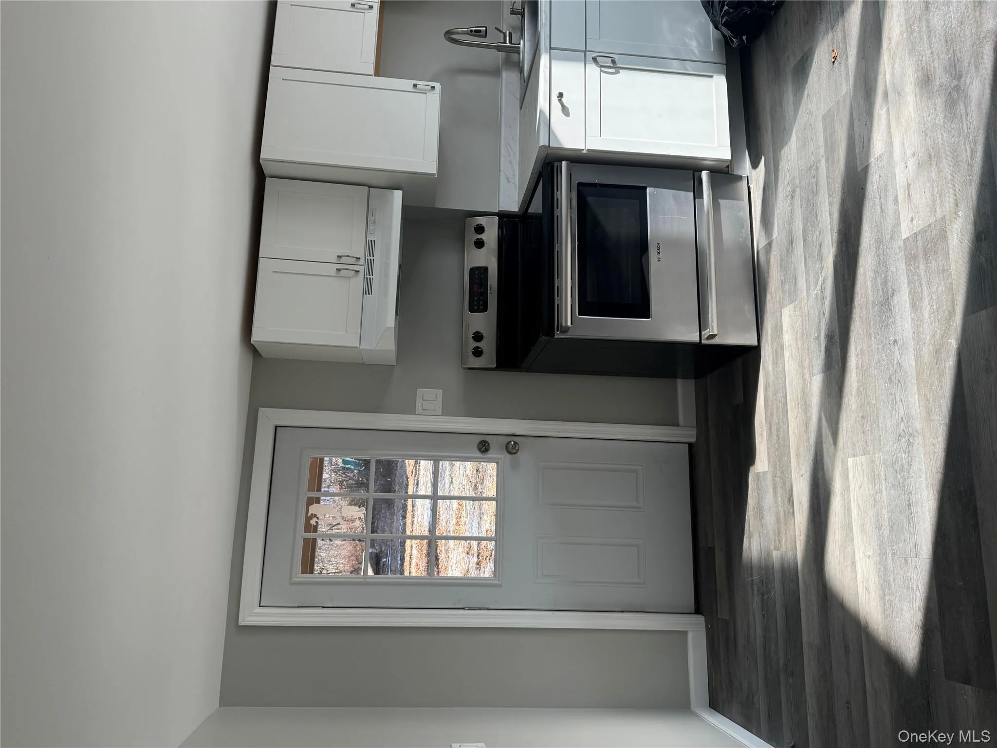 Kitchen featuring range, ventilation hood, white cabinetry, and sink Kitchen featuring range, ventilation hood, white cabinetry, and sink