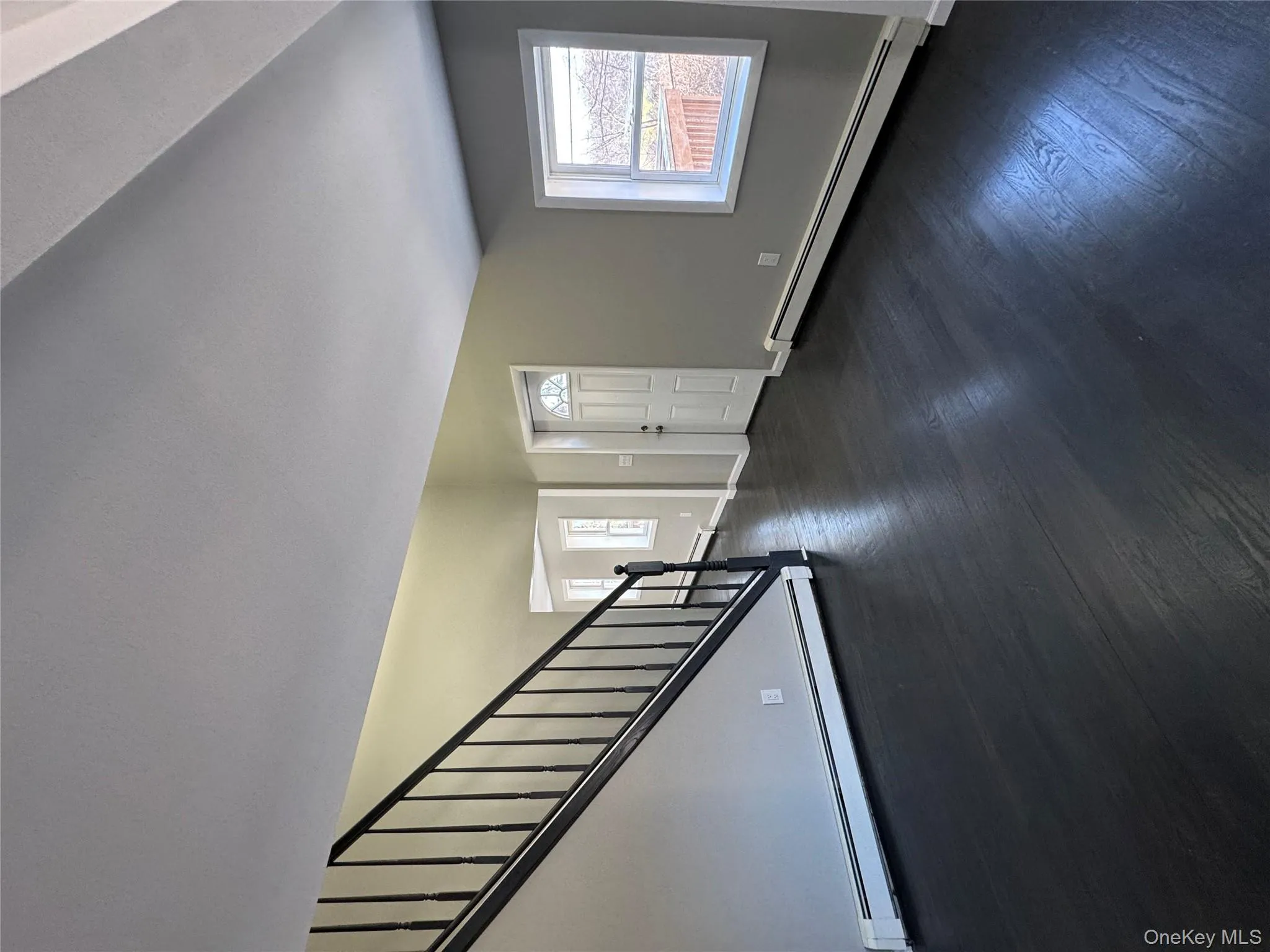 Foyer featuring a baseboard radiator and dark hardwood / wood-style floors Foyer featuring a baseboard radiator and dark hardwood / wood-style floors