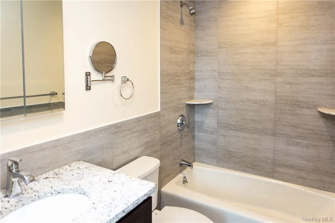 The vanity cabinetry and granite all match between kitchen and bath. Porcelain tile from Italy on the walls and floor. The vanity cabinetry and granite all match between kitchen and bath. Porcelain tile from Italy on the walls and floor.