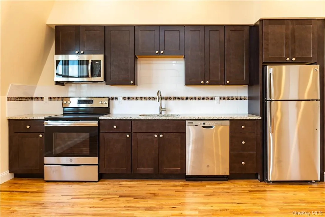 Custom designed kitchen features soft-closing cabinetry, granite counters and tiled back-splash with decorative border. Custom designed kitchen features soft-closing cabinetry, granite counters and tiled back-splash with decorative border.