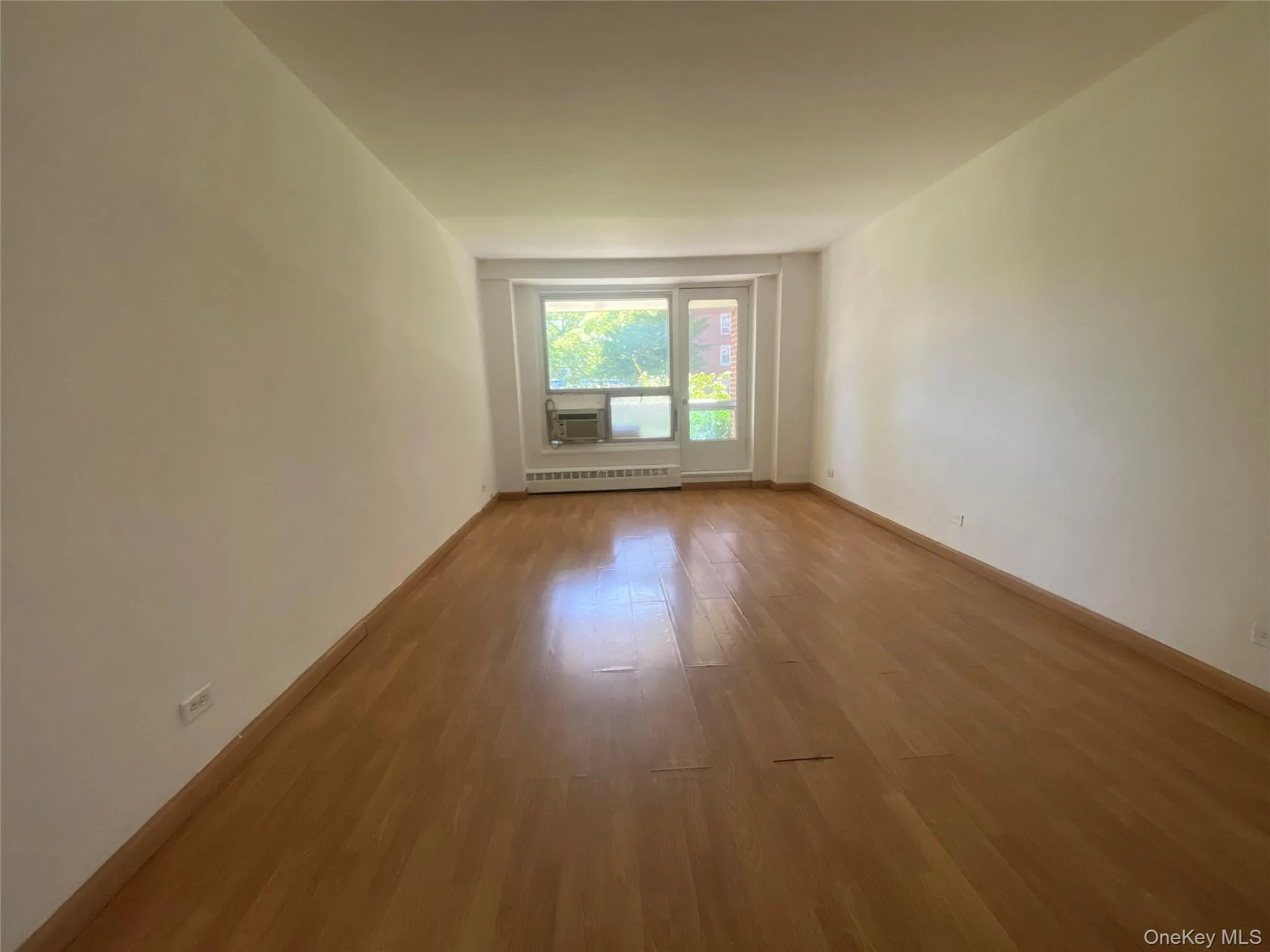 Empty room featuring wood finished floors and baseboards Empty room featuring wood finished floors and baseboards
