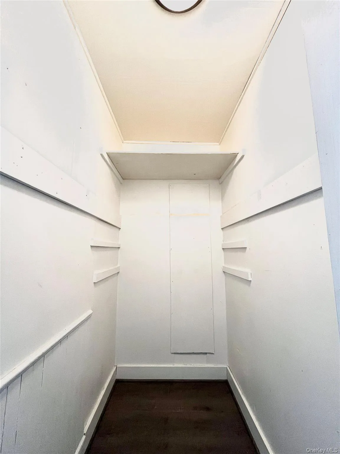 Walk in closet with dark wood finished floors Walk in closet with dark wood finished floors