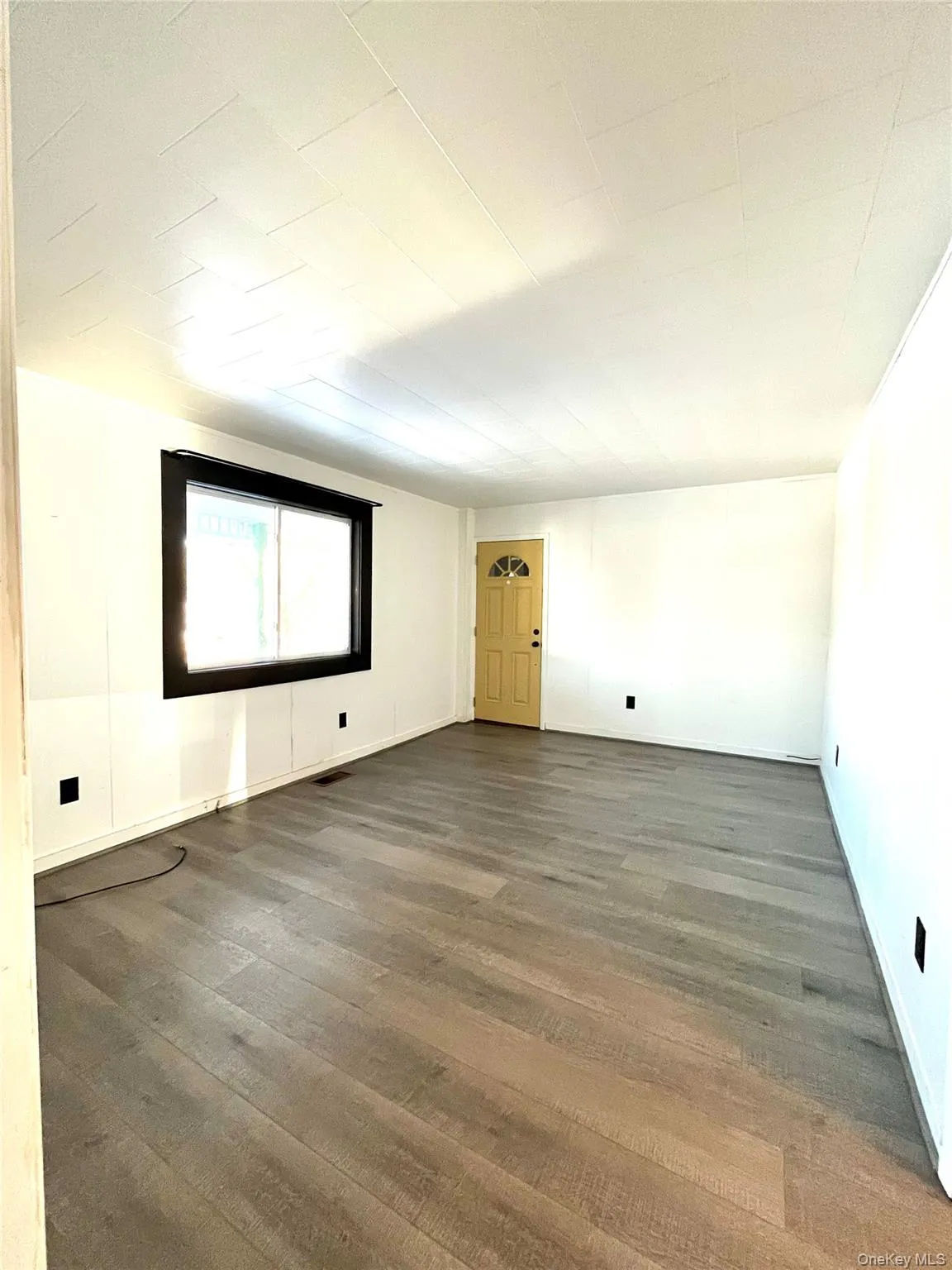 Unfurnished room with wood finished floors, shows other entrance door, not to be used at the moment. Unfurnished room with wood finished floors, shows other entrance door, not to be used at the moment.