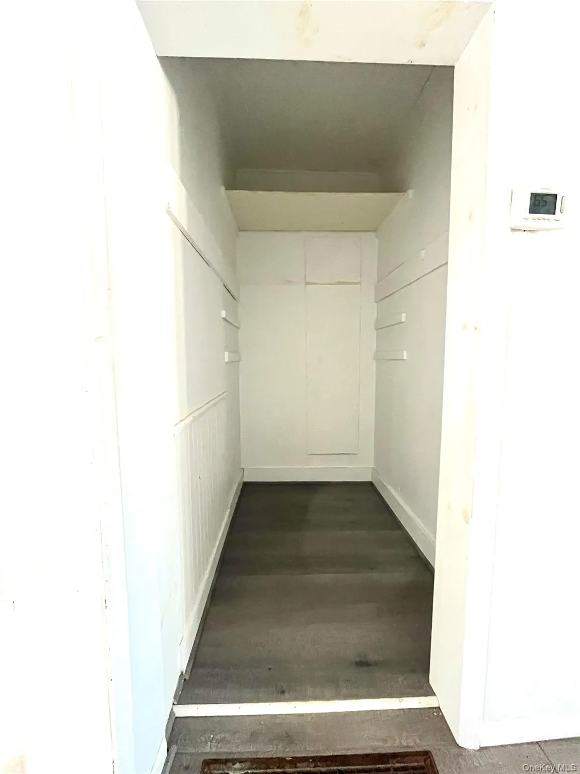 Hallway with dark wood-style floors and baseboards Hallway with dark wood-style floors and baseboards