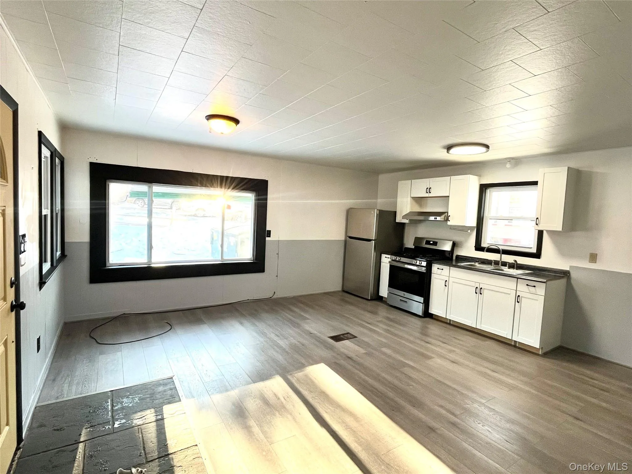 Kitchen with white cabinets, appliances with stainless steel finishes, dark countertops, and light wood-style flooring Kitchen with white cabinets, appliances with stainless steel finishes, dark countertops, and light wood-style flooring