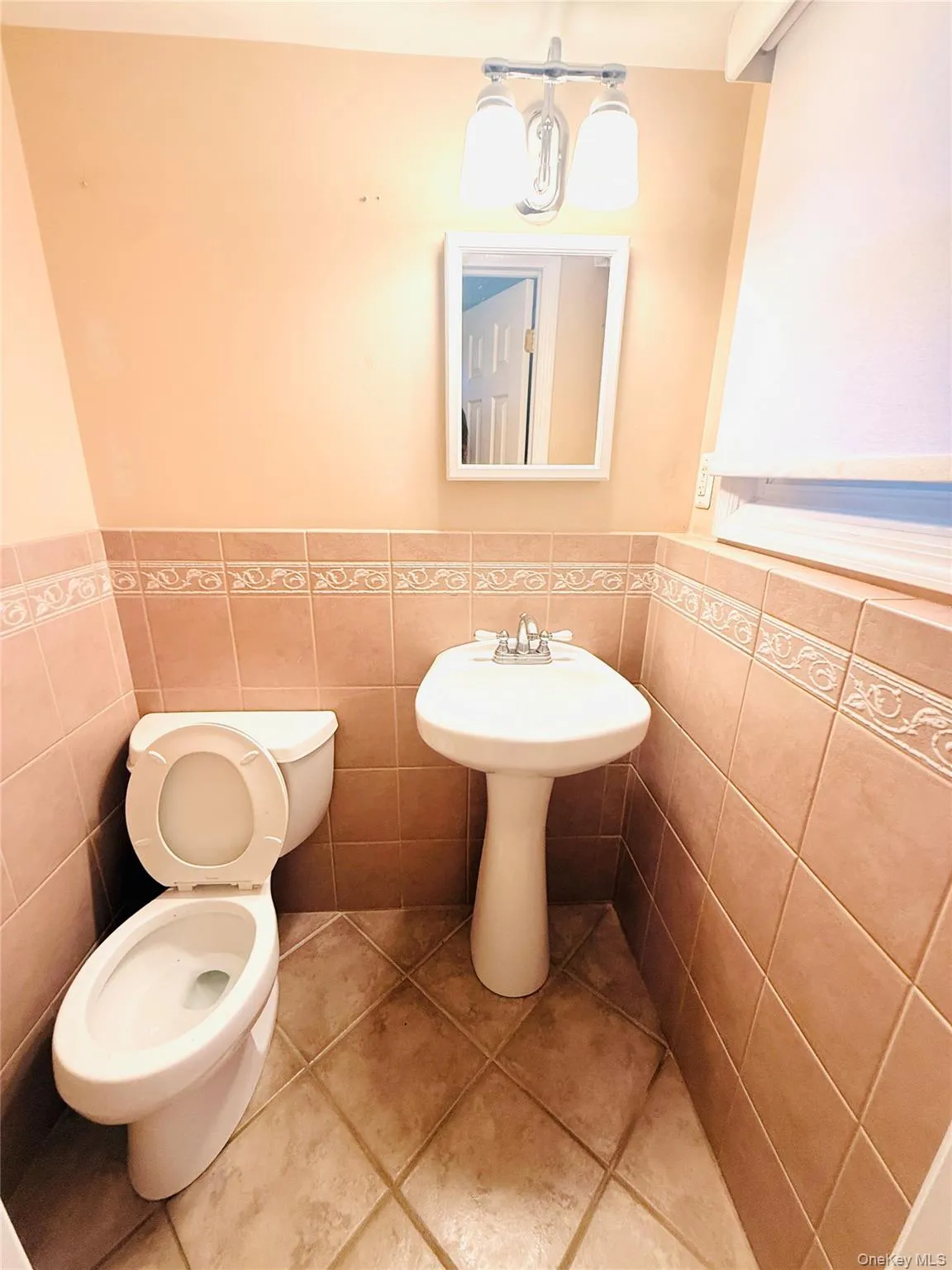 Half bath with wainscoting, tile patterned flooring, and tile walls Half bath with wainscoting, tile patterned flooring, and tile walls