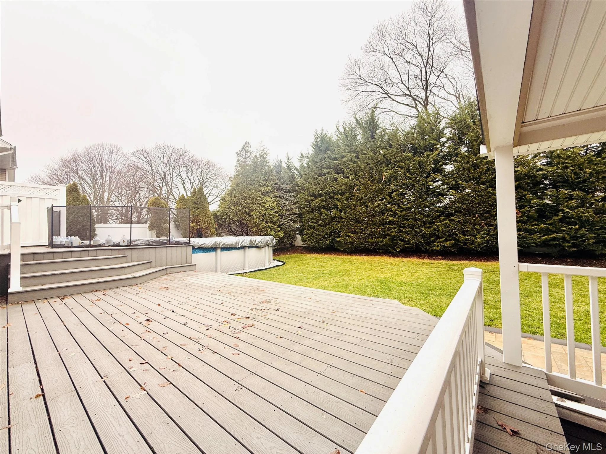 Wooden terrace with a covered pool and a lawn Wooden terrace with a covered pool and a lawn
