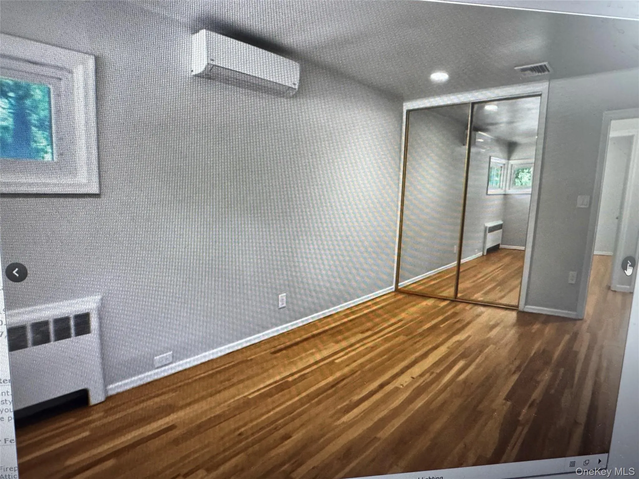 Unfurnished bedroom with radiator, a wall unit AC, dark wood-style floors, a closet, and recessed lighting Unfurnished bedroom with radiator, a wall unit AC, dark wood-style floors, a closet, and recessed lighting
