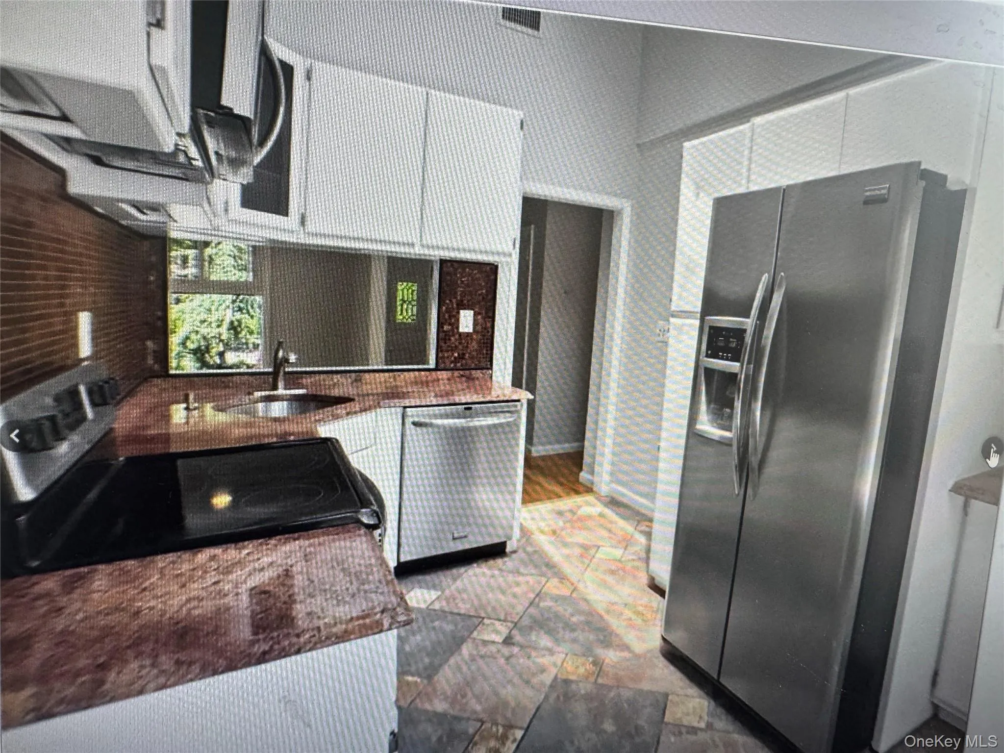 Kitchen with stainless steel appliances and stone tile floors Kitchen with stainless steel appliances and stone tile floors