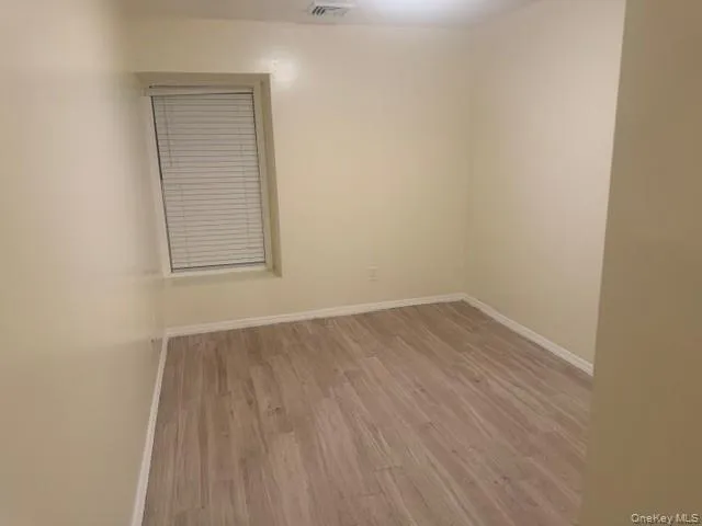 Empty room with baseboards and light wood-type flooring Empty room with baseboards and light wood-type flooring