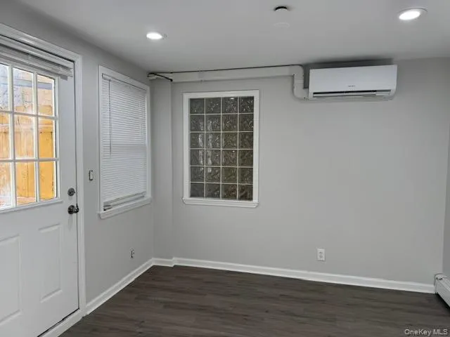 a wall unit AC, with side door to the balcony. wood finished floors, and recessed lighting a wall unit AC, with side door to the balcony. wood finished floors, and recessed lighting