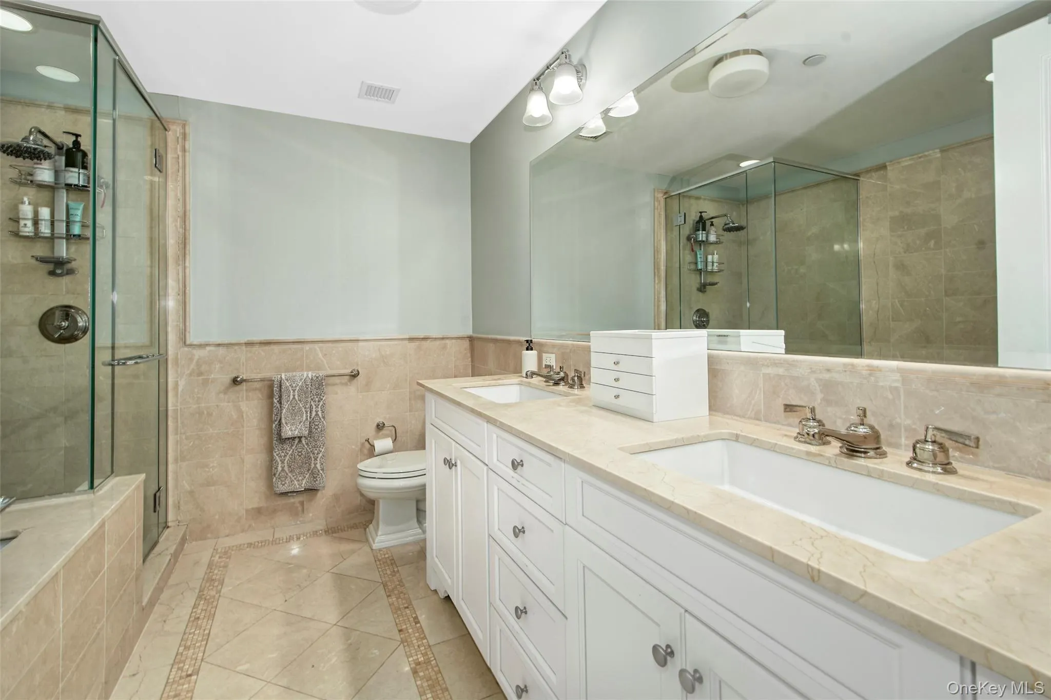 Primary bathroom with double vanity, marble tile, tub and shower. Primary bathroom with double vanity, marble tile, tub and shower.