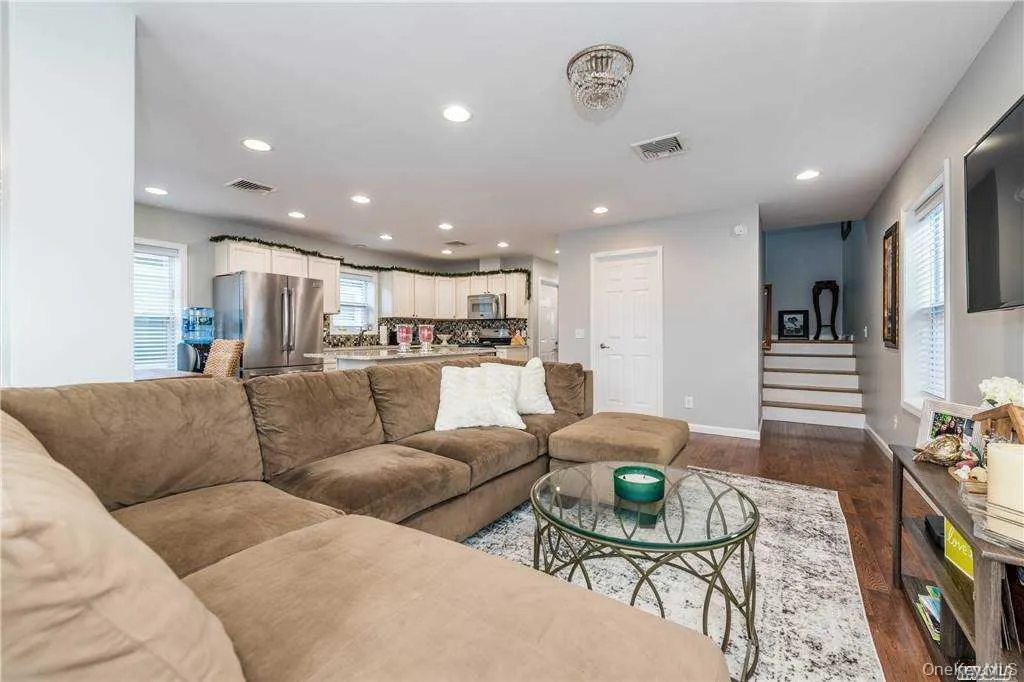 Living area featuring stairway, recessed lighting, and dark wood finished floors Living area featuring stairway, recessed lighting, and dark wood finished floors