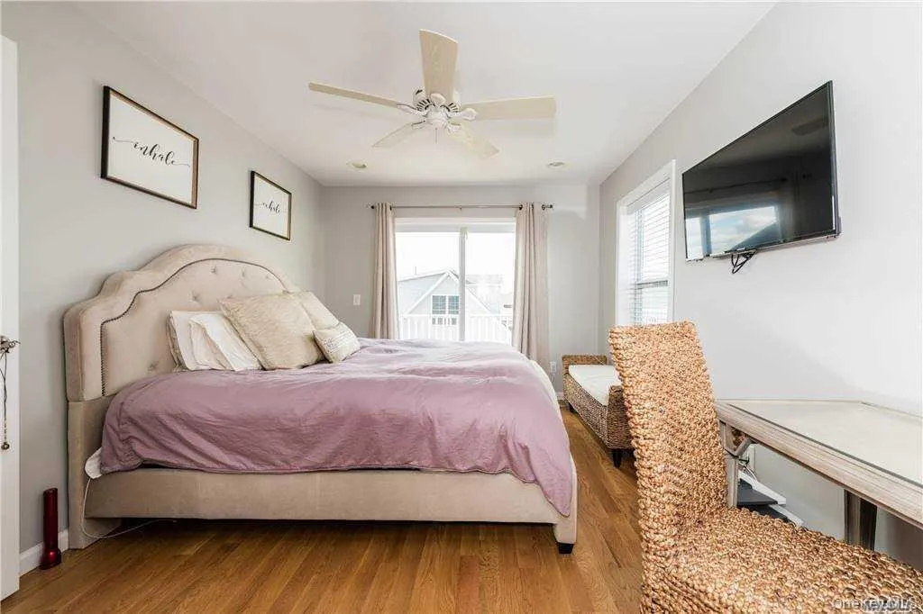 Bedroom featuring access to outside, a ceiling fan, and wood finished floors Bedroom featuring access to outside, a ceiling fan, and wood finished floors