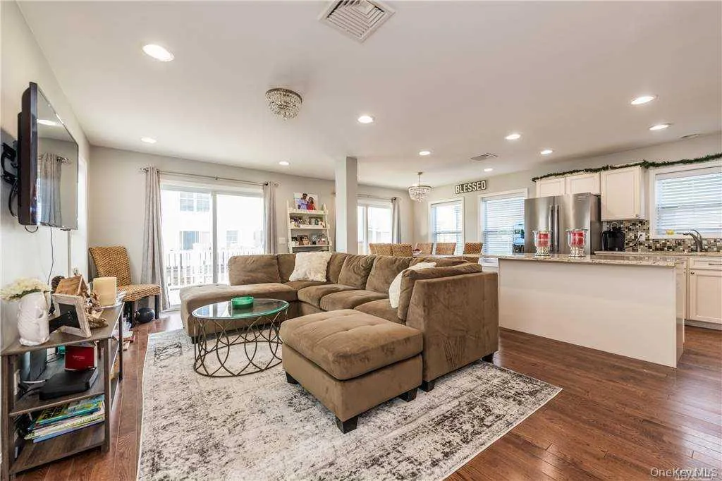 Living area with plenty of natural light, recessed lighting, and dark wood-style floors Living area with plenty of natural light, recessed lighting, and dark wood-style floors