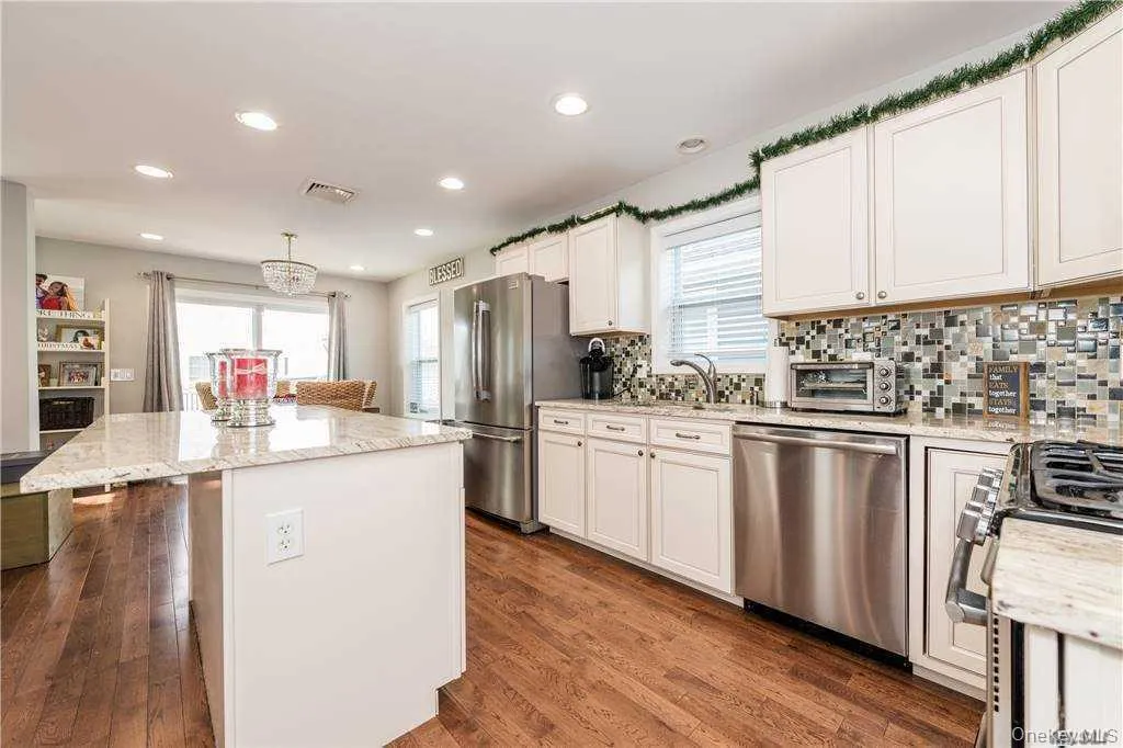 Kitchen with appliances with stainless steel finishes, light stone countertops, plenty of natural light, and recessed lighting Kitchen with appliances with stainless steel finishes, light stone countertops, plenty of natural light, and recessed lighting