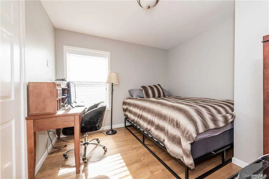 Bedroom with light wood finished floors and a desk Bedroom with light wood finished floors and a desk