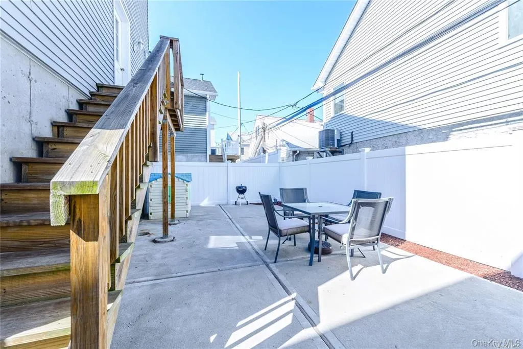 Fenced backyard with a patio area, stairway, and outdoor dining area Fenced backyard with a patio area, stairway, and outdoor dining area