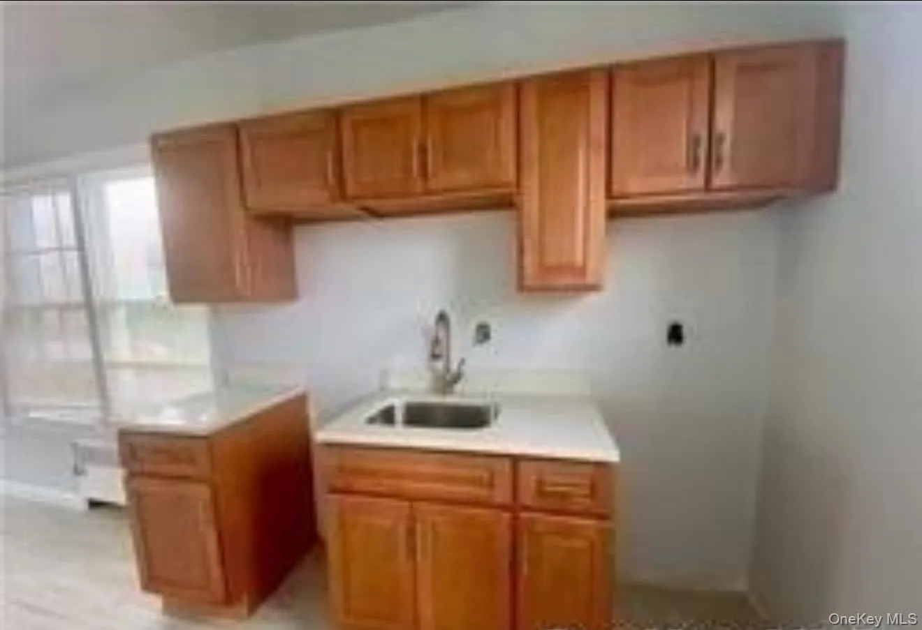 Kitchen featuring brown cabinetry and light countertops Kitchen featuring brown cabinetry and light countertops